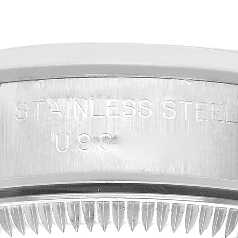 The image shows a close-up of the stainless steel casing with engravings on a Rolex Oyster Perpetual 67180 Women's Stainless Steel Pink Dial 67180 Women's Stainless Steel Pink Dial watch.