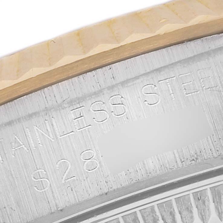 The image shows a close-up of the bezel and parts of the engraved case of a Rolex Oyster Perpetual M67193 Women's Steel and Gold (two tone) Champagne Dial M67193 Women's Steel and Gold (two tone) Champagne Dial watch.