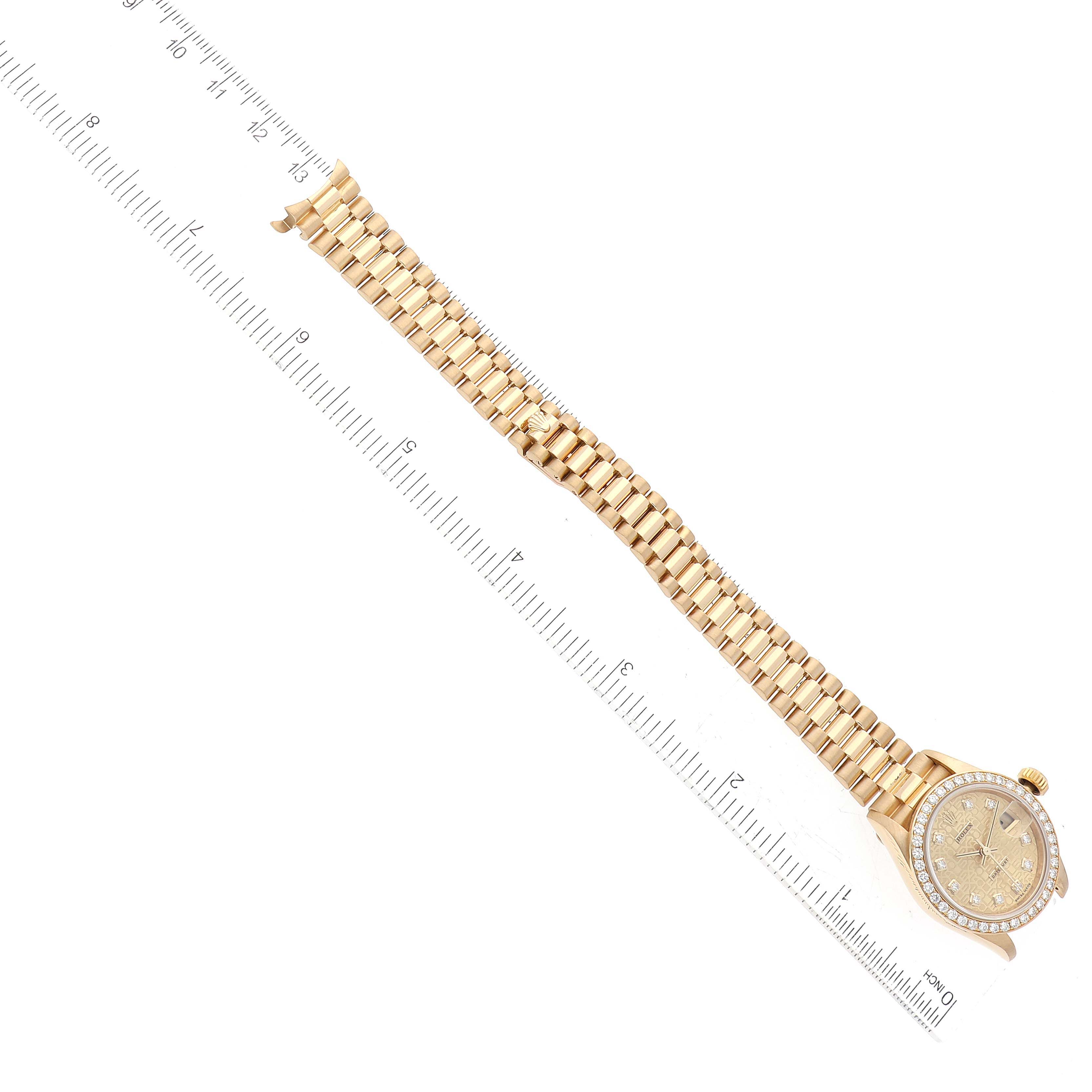 The Rolex President 79138G Women
s Yellow Gold Champagne Dial 79138G Women
s Yellow Gold Champagne Dial model watch is shown lying flat with its full bracelet and face visible next to a ruler.