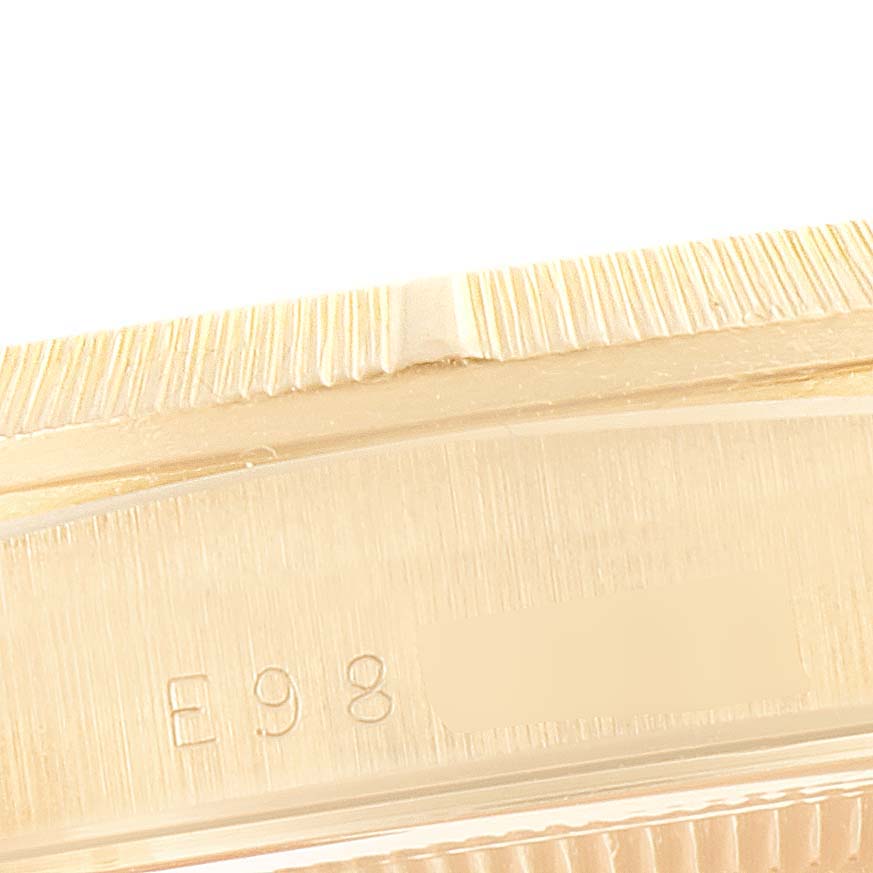 This close-up image shows a partial view of the bezel and case, including serial number markings, on a Rolex President 18248 Men
s Yellow Gold Black Dial 18248 Men
s Yellow Gold Black Dial model watch.
