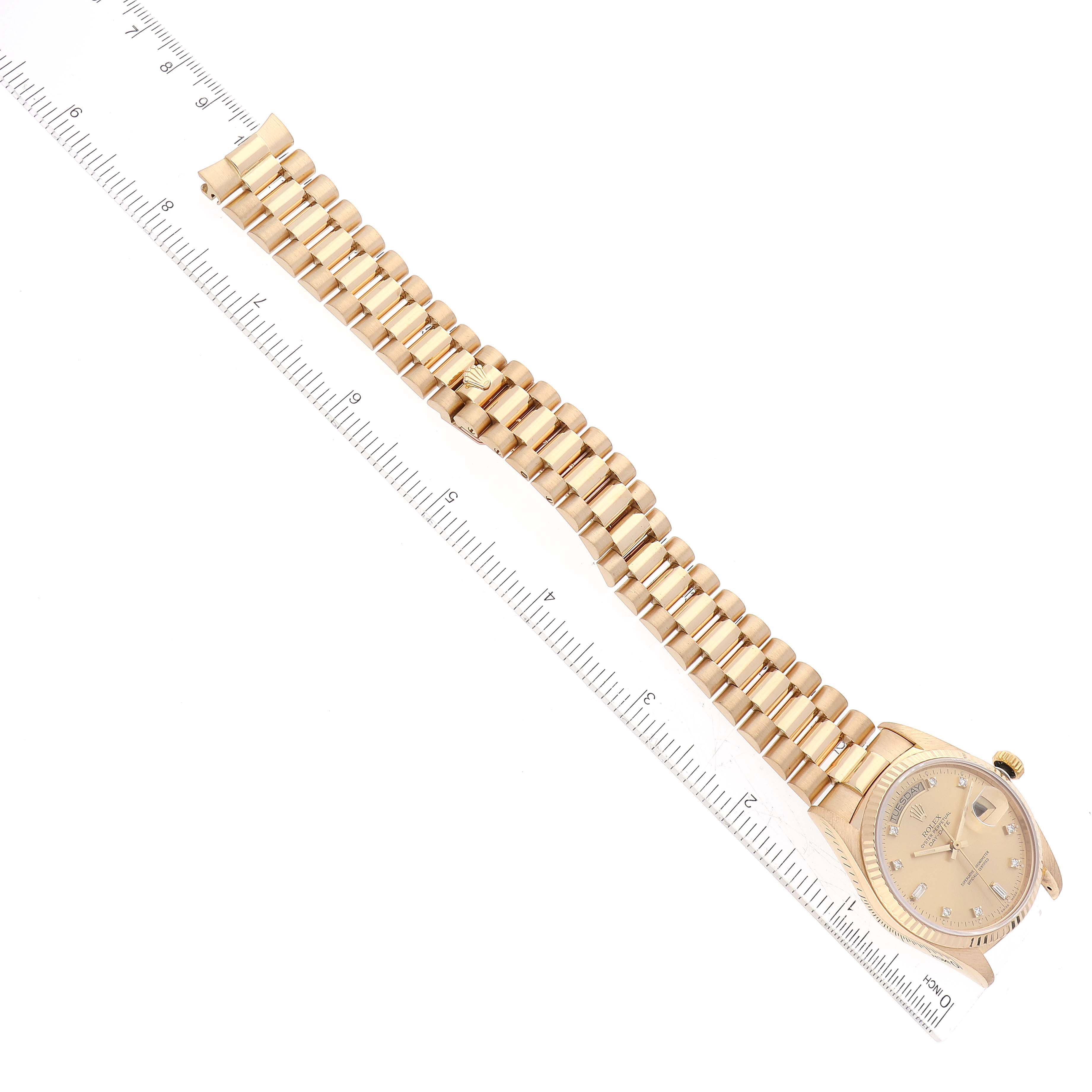 The image shows a Rolex President 18038A Men
s Yellow Gold Champagne Dial 18038A Men
s Yellow Gold Champagne Dial model watch with a gold case and bracelet, alongside a measuring ruler for scale.