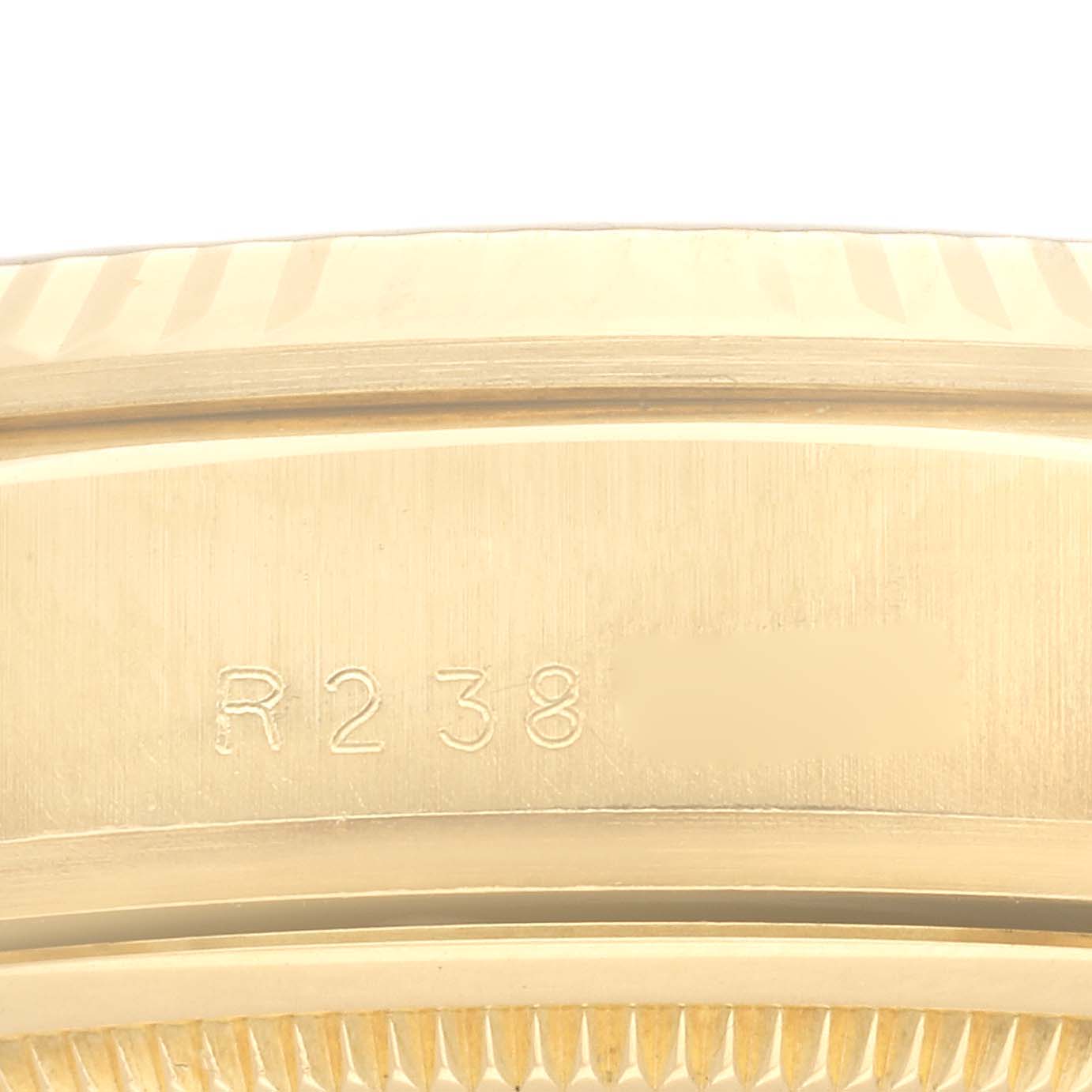 This is a close-up shot of the case side of a Rolex President 18038A Men
s Yellow Gold Champagne Dial 18038A Men
s Yellow Gold Champagne Dial model, showing part of the serial number engraving.