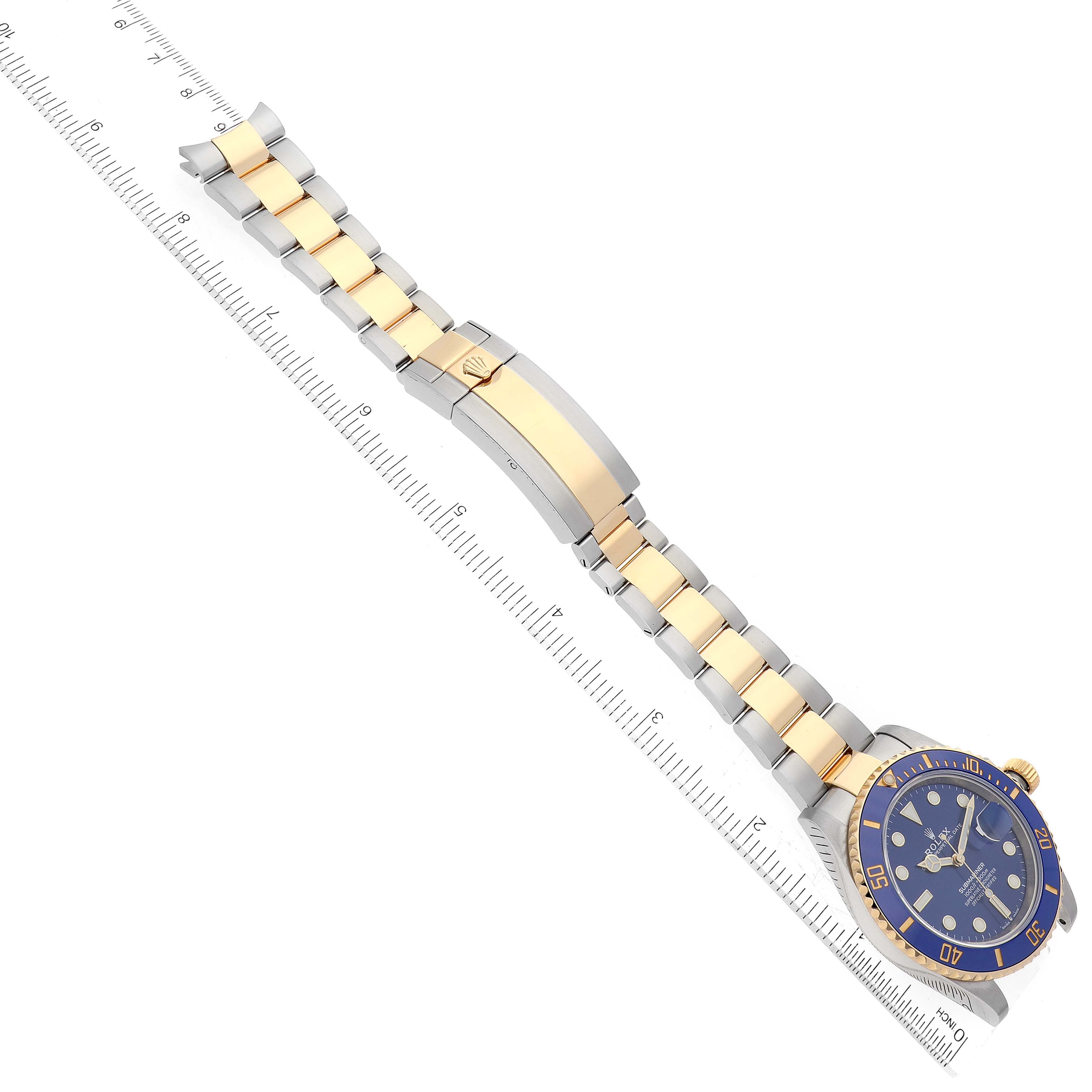 This image shows a Rolex Submariner 126613LB Men's Steel and Gold (two tone) Blue Dial 126613LB Men's Steel and Gold (two tone) Blue Dial watch laid flat with a ruler for measurement.