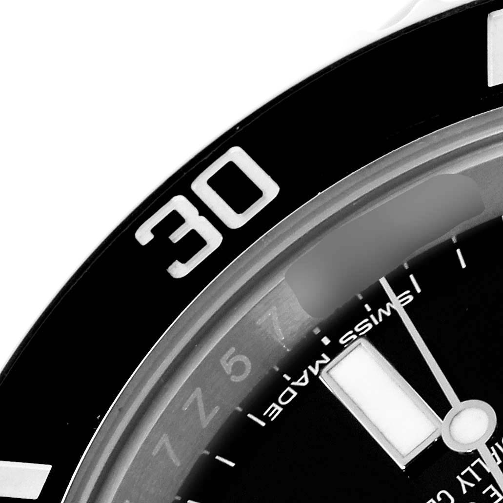 This image shows a close-up of the bezel and part of the dial of a Rolex Submariner 114060 Men's Stainless Steel Black Dial 114060 Men's Stainless Steel Black Dial watch, indicating the 30-minute mark.