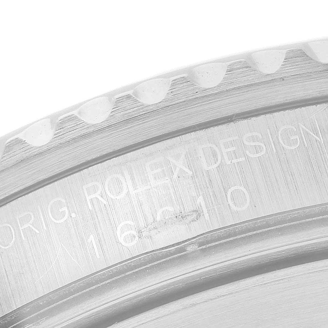 The image shows a close-up of the engraved case back edge and bezel of a Rolex Submariner 16610 Men's Stainless Steel Black Dial.