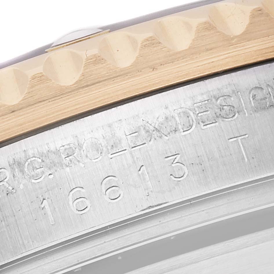 The image shows a close-up of the side of the Rolex Submariner 16613 Men's Steel and Gold (two tone) Champagne Dial 16613 Men's Steel and Gold (two tone) Champagne Dial, focusing on the bezel edge and engraved model number.