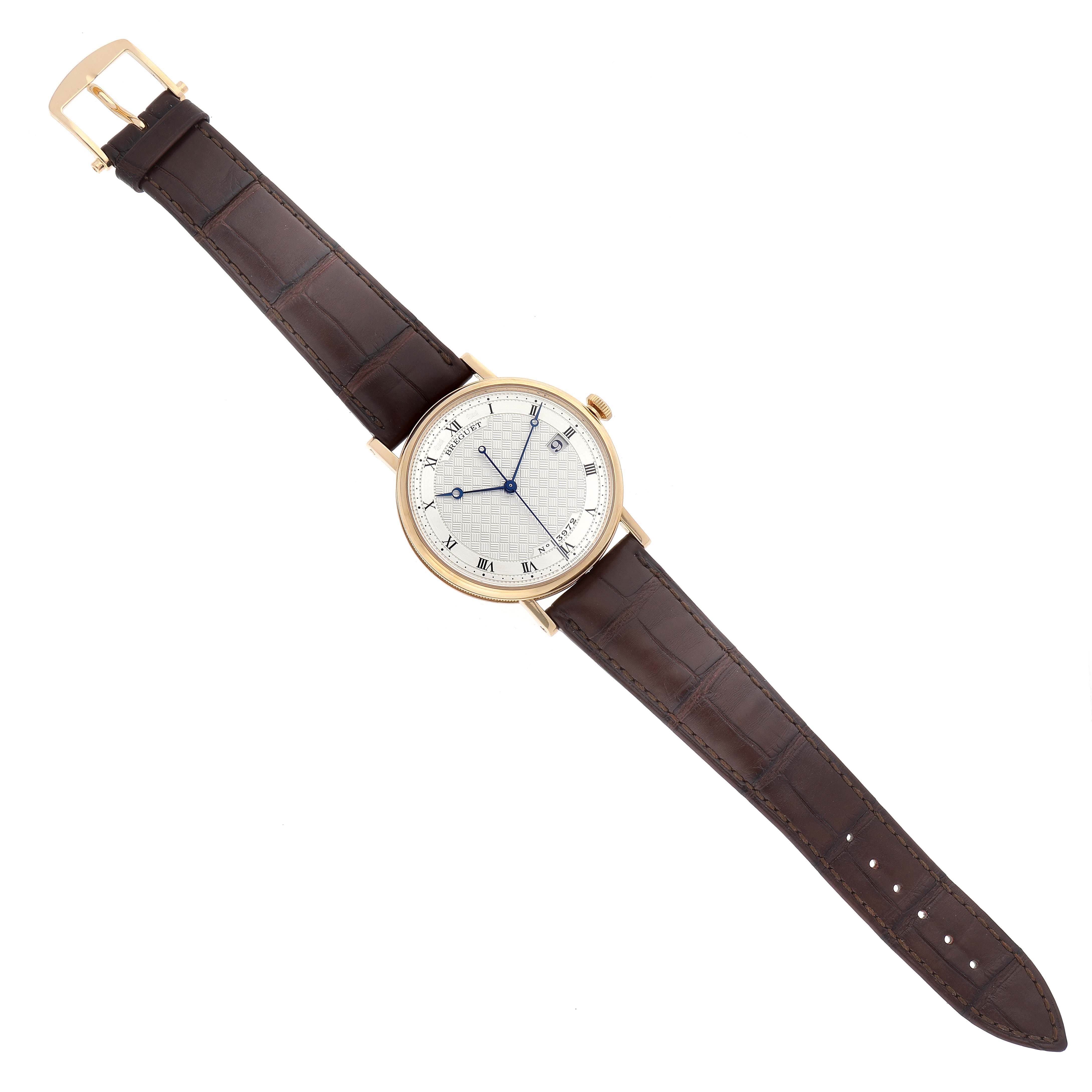 The Breguet Classique 5177BA/12/9V6 Men's Yellow Gold Silver Dial 5177BA/12/9V6 Men's Yellow Gold Silver Dial watch is shown from a top-down angle, displaying the dial, case, and leather strap.