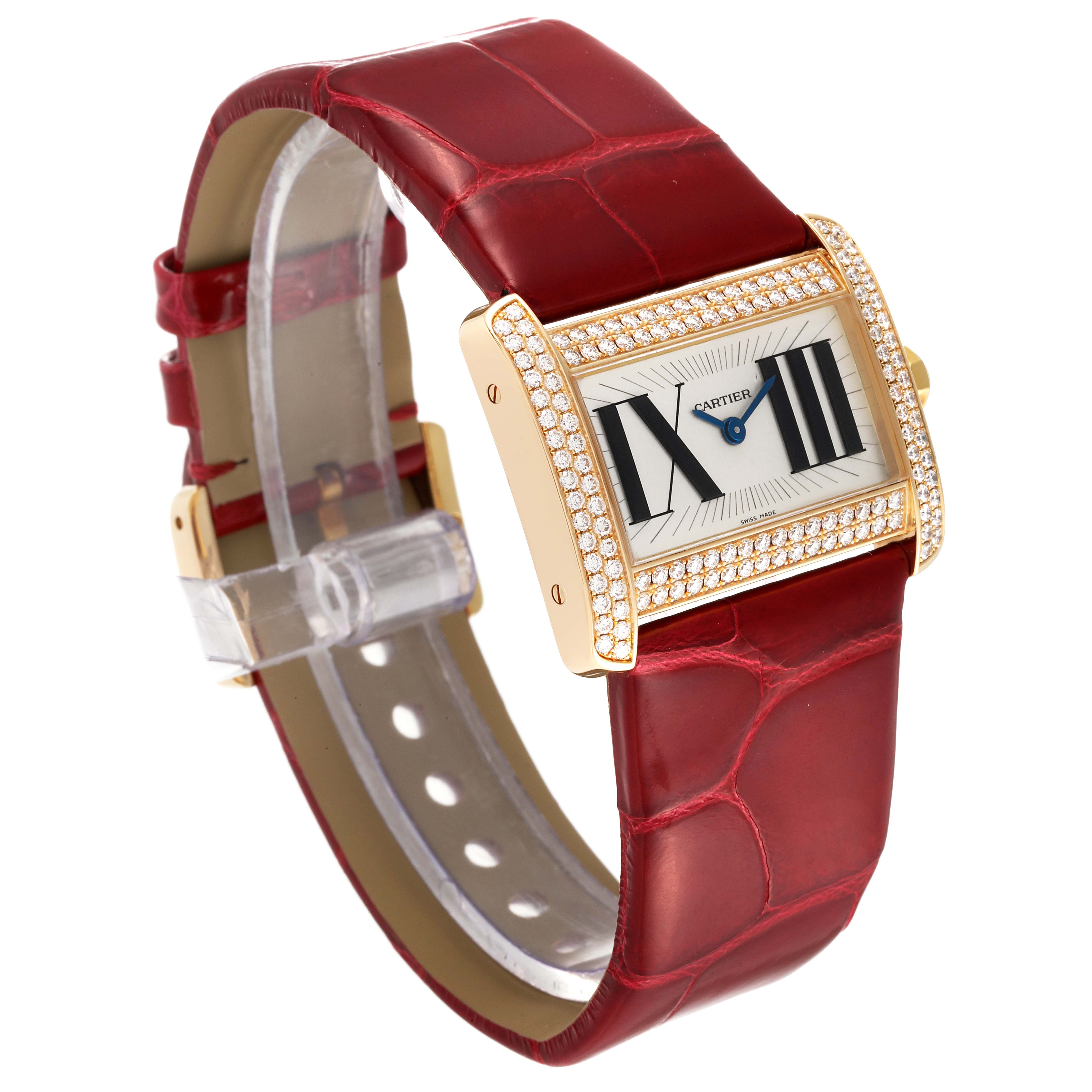 The image shows a Cartier Tank Divan WA301471 Women
s Yellow Gold Silver Dial WA301471 Women
s Yellow Gold Silver Dial watch at an angle highlighting its red leather strap and adorned rectangular face.