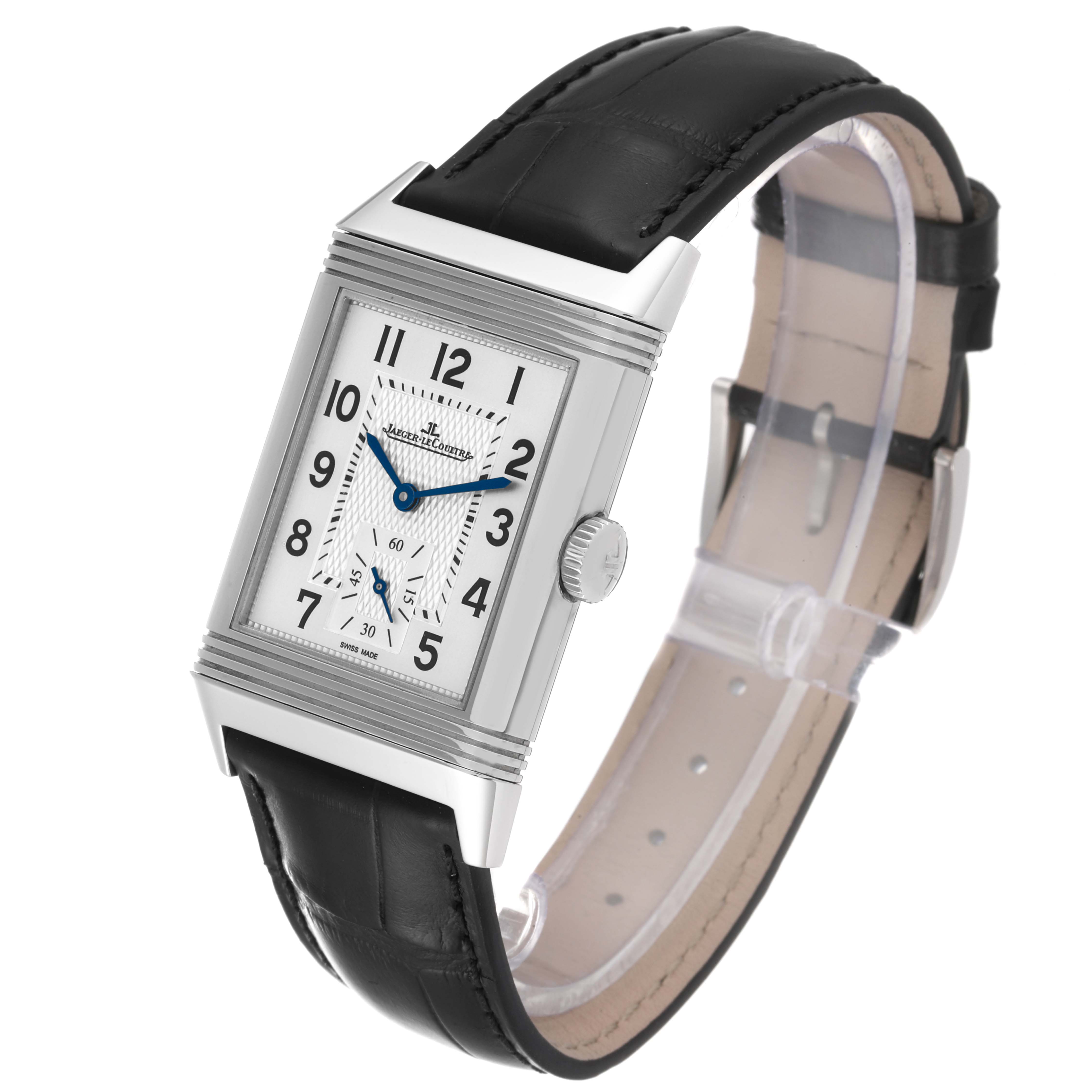 The image shows a Jaeger-LeCoultre Reverso watch at a three-quarter angle, highlighting its rectangular face, crown, and black leather strap.