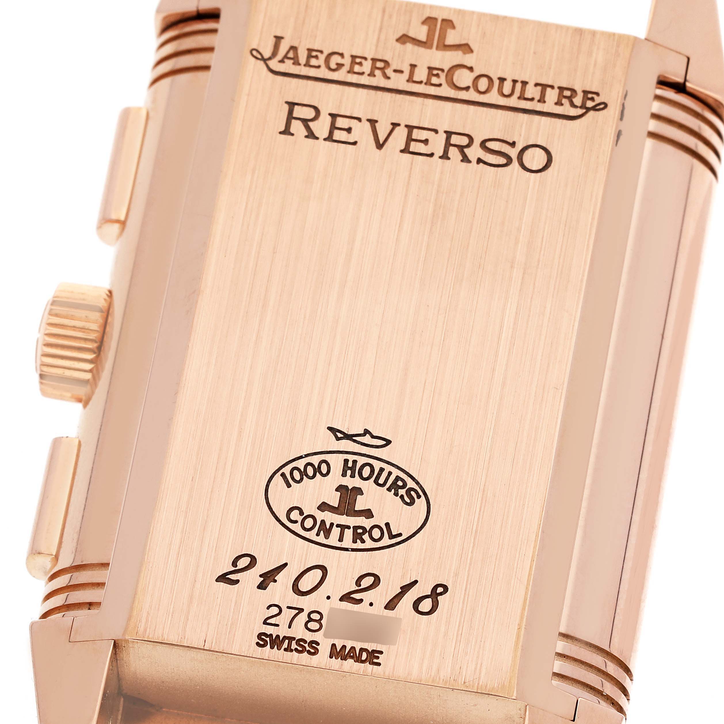 The image shows the reverse side of the Jaeger-LeCoultre Reverso watch, featuring engravings and control stamps.