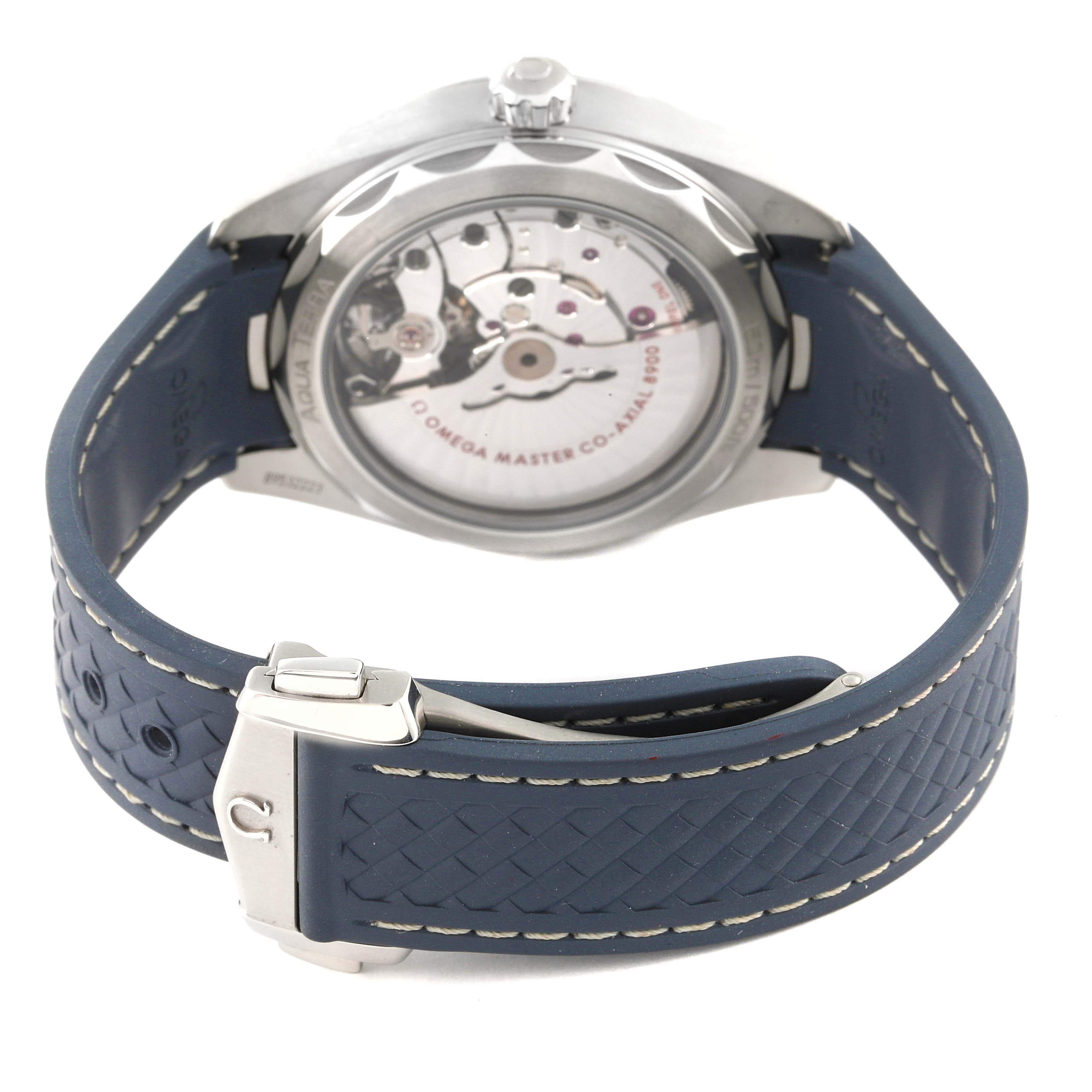 The image shows the back view of the Omega Aqua Terra 220.12.41.21.03.002 Men's Stainless Steel Blue Dial 220.12.41.21.03.002 Men's Stainless Steel Blue Dial watch, highlighting its movement and blue strap with clasp.