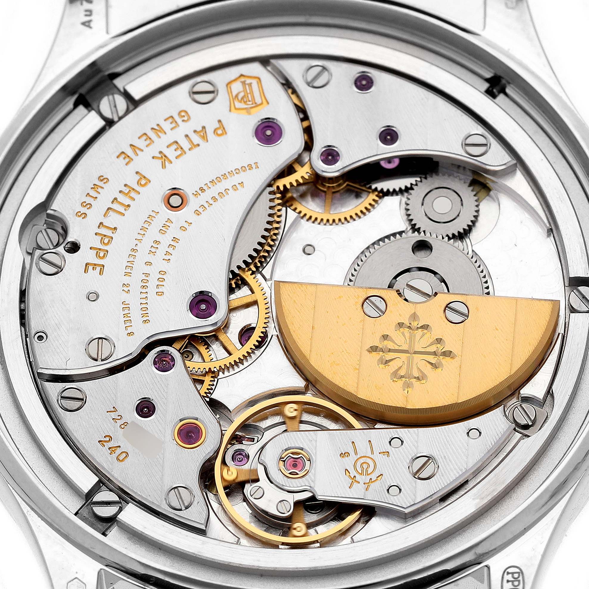 The image shows the movement of a Patek Philippe Calatrava 4997 Women's White Gold Blue Dial watch from a top-down angle, highlighting gears and the rotor.