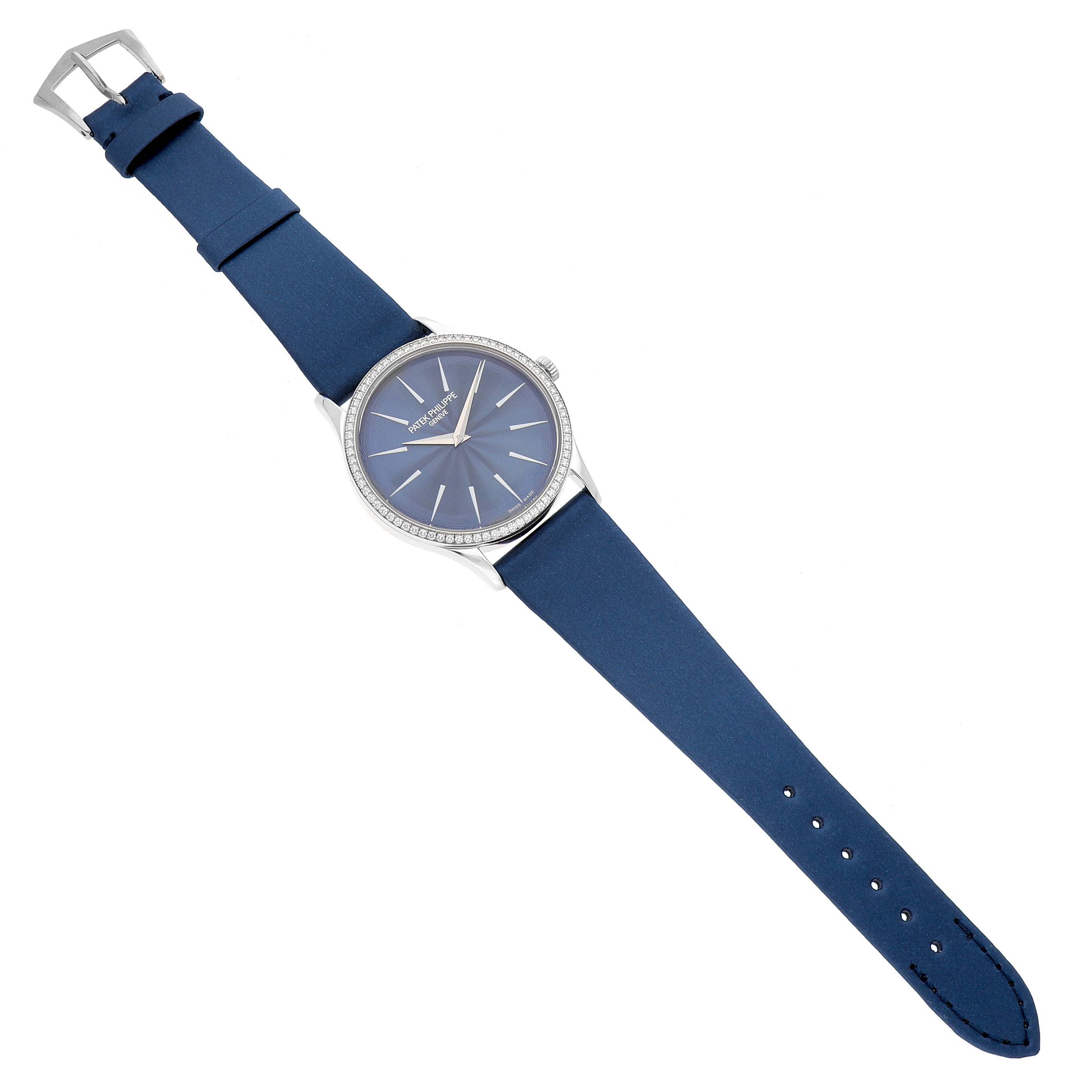 The Patek Philippe Calatrava 4997 Women's White Gold Blue Dial watch is shown from an overhead angle, displaying its blue dial, silver case, and blue strap with a buckle.