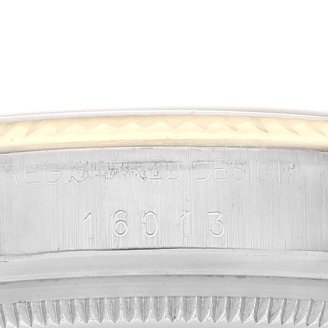 The image shows a close-up view of the serial number area and the fluted bezel of a Rolex Datejust 16013 Men's Steel and Gold (two tone) Black Dial 16013 Men's Steel and Gold (two tone) Black Dial model watch.