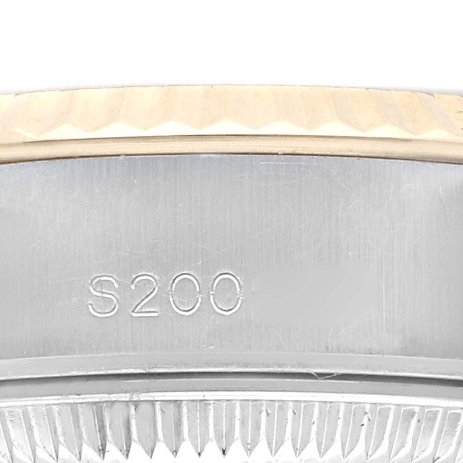 This image shows a close-up of the side engraving and fluted bezel of a Rolex Datejust 69173G Women's Steel and Gold (two tone) Champagne Dial 69173G Women's Steel and Gold (two tone) Champagne Dial watch.