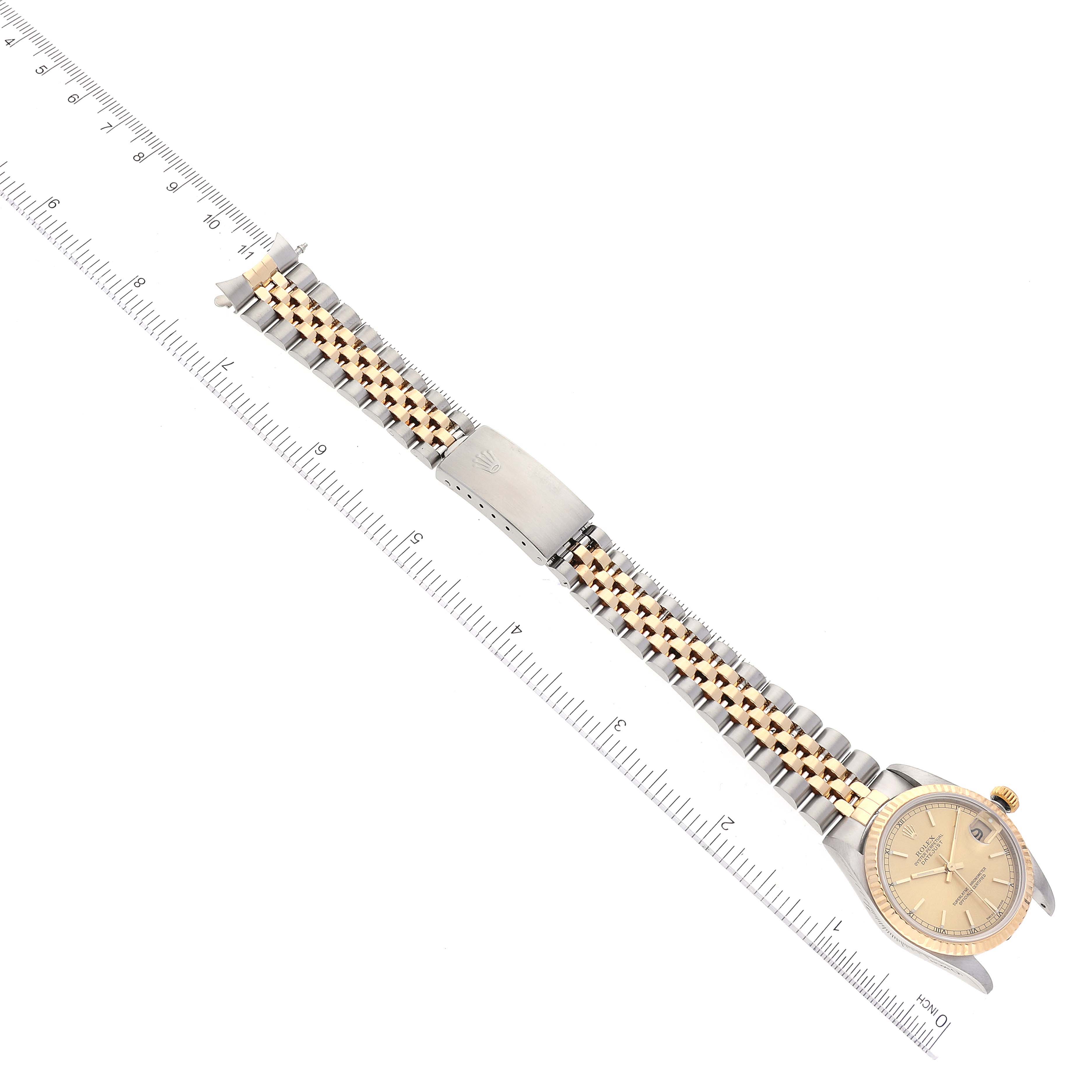 The image shows a Rolex Mid-Size 78273 Women's Steel and Gold (two tone) Champagne Dial 78273 Women's Steel and Gold (two tone) Champagne Dial watch from an angled top view, displaying the bracelet, clasp, dial, and surrounding rulers for scale.