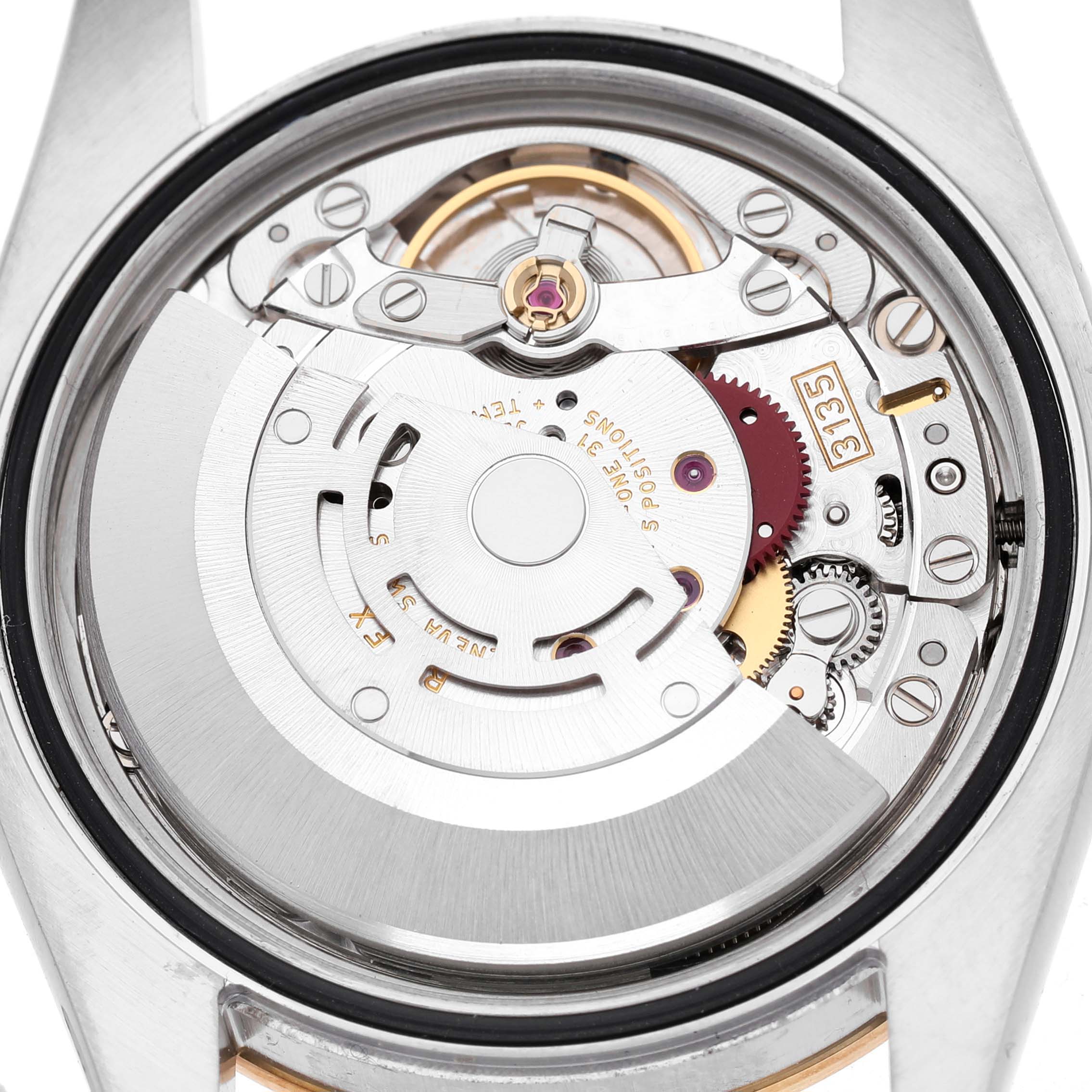 The image shows a close-up of the movement mechanism of a Rolex Datejust 116243 Men's Steel and Gold (two tone) Silver Dial watch, viewed from the back.