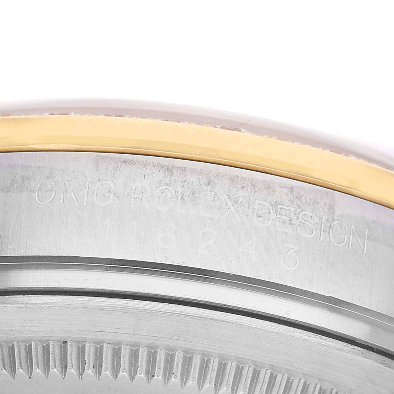 The image shows a close-up of the Rolex Datejust 116243 Men's Steel and Gold (two tone) Champagne Dial case side, with engraved text and part of the bezel visible.