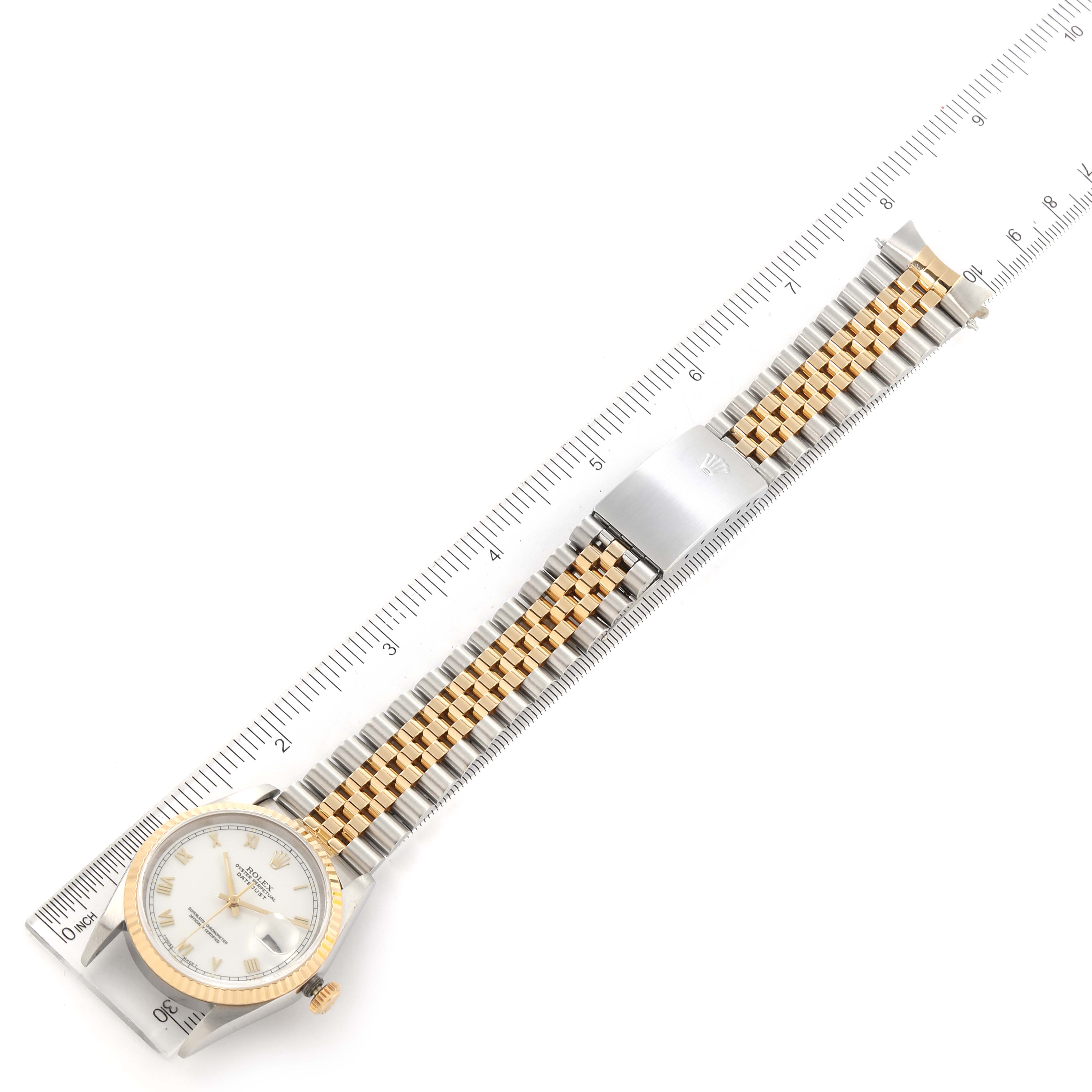 The Rolex Datejust 16233 Men's Steel and Gold (two tone) White Dial 16233 Men's Steel and Gold (two tone) White Dial watch is shown from a top-down angle, displaying its face, bracelet, and clasp next to a ruler for scale.