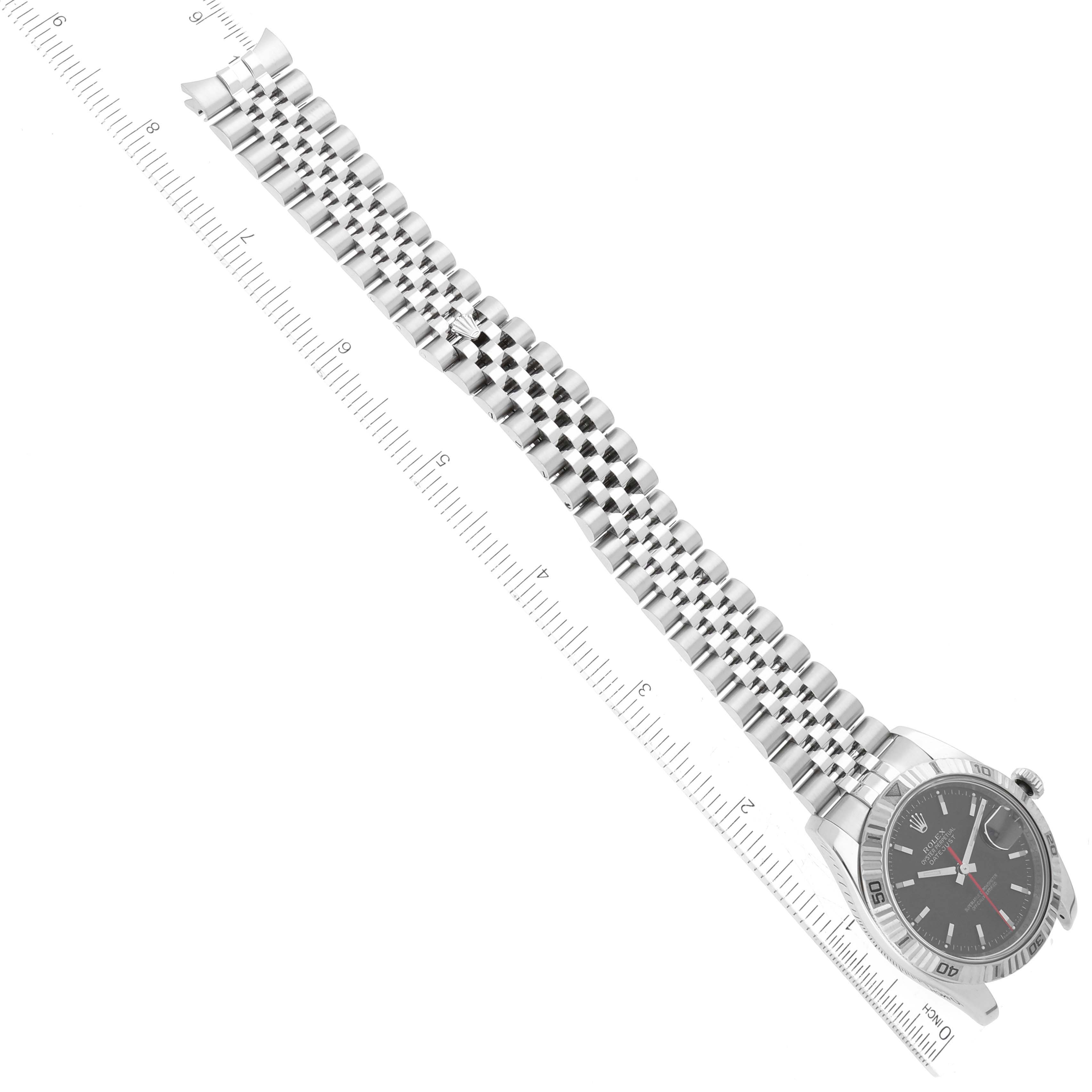 This image shows a top-down view of a Rolex Turn-o-Graph 116264 Men's Stainless Steel Black Dial 116264 Men's Stainless Steel Black Dial watch, including its face, bezel, and bracelet next to a ruler.