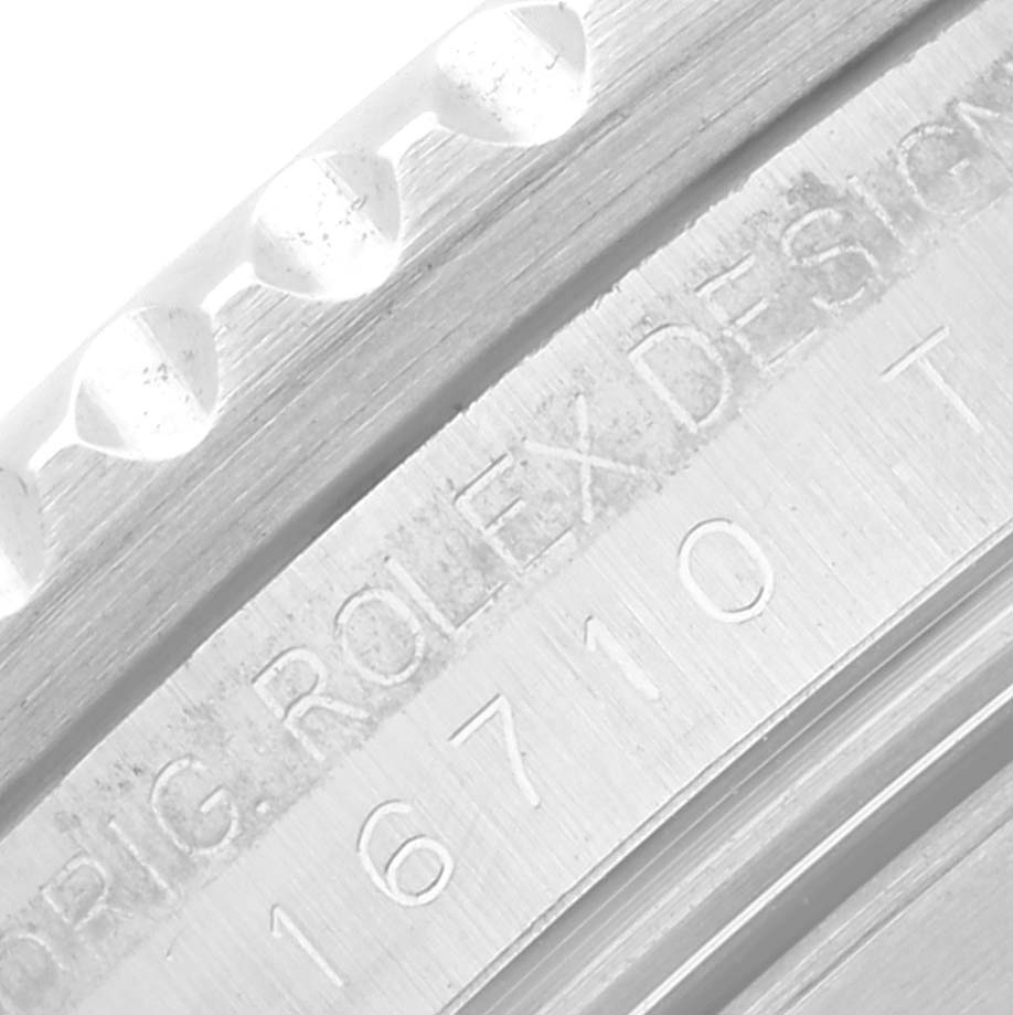 This close-up image of the Rolex GMT-Master 16710 Men's Stainless Steel Black Dial 16710 Men's Stainless Steel Black Dial watch shows part of the bezel edge and model engraving "16710."