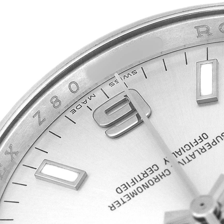 The image shows a close-up of the Rolex Air-King 114200 Men's Stainless Steel Silver Dial watch face, highlighting the 9 o’clock marker and part of the bezel with text.