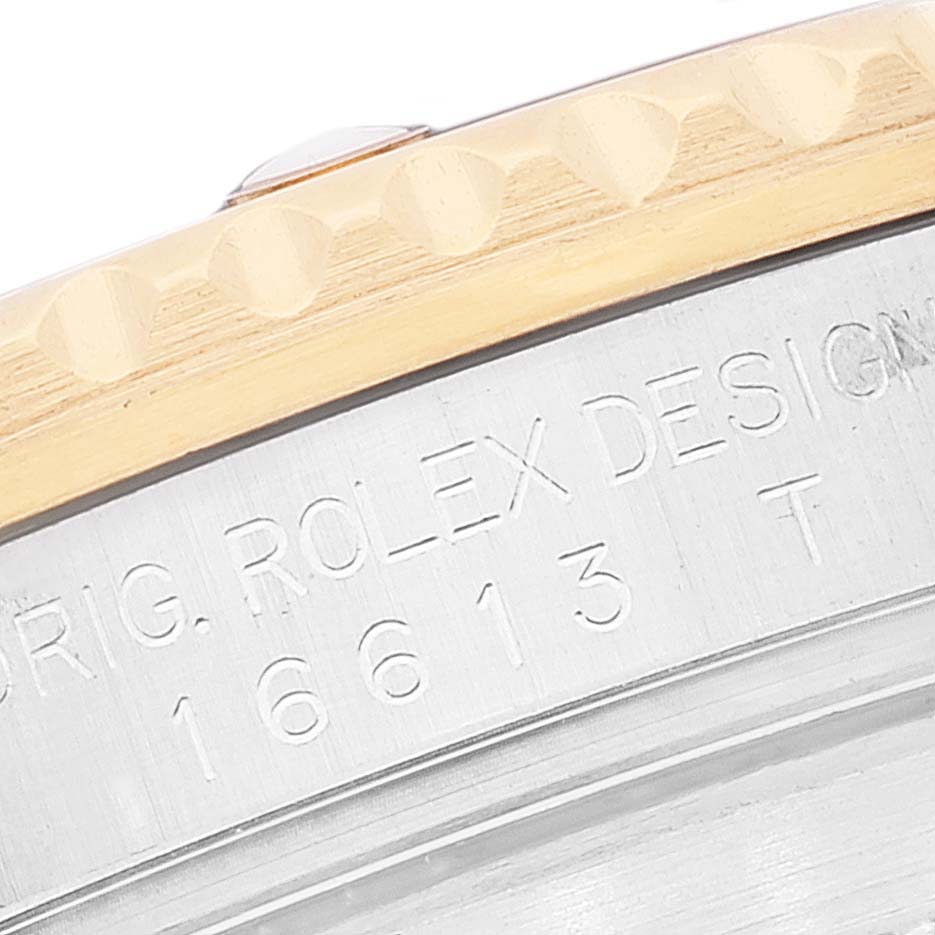 This close-up image shows the engraved outer bezel and part of the case of a Rolex Submariner 16613T Men's Steel and Gold (two tone) Grey Dial 16613T Men's Steel and Gold (two tone) Grey Dial watch.