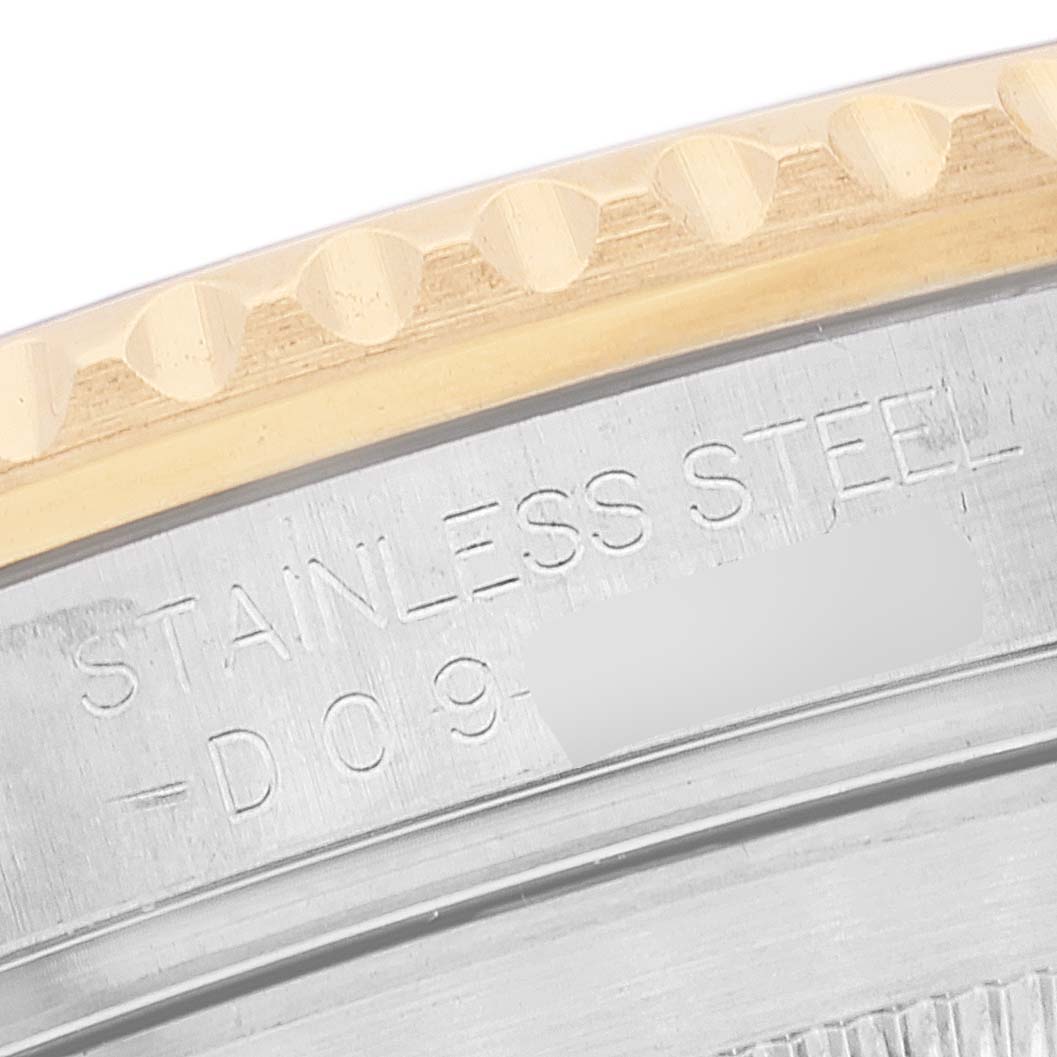 The image shows a close-up of the bezel and case back of a Rolex Submariner 16613T Men's Steel and Gold (two tone) Grey Dial 16613T Men's Steel and Gold (two tone) Grey Dial, highlighting the engraved text "STAINLESS STEEL".