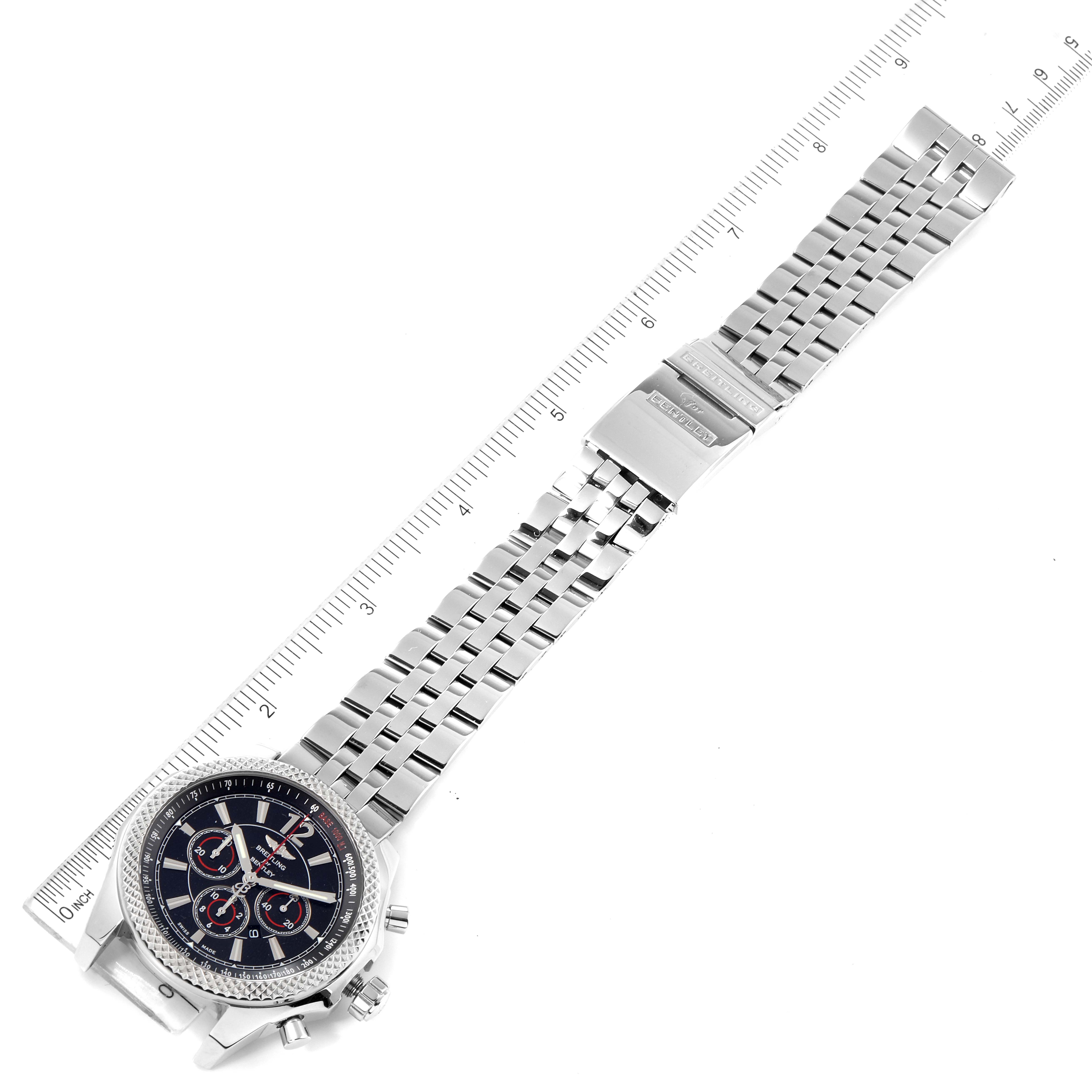 The Bentley model by Breitling is shown at a top-down angle featuring the bezel, dial, chronograph, and metal bracelet alongside a ruler.