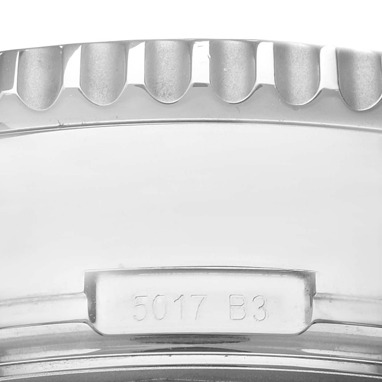 This image shows a close-up of the side of the case of a Breitling Navitimer AB0310 Men's Stainless Steel Brown Dial AB0310 Men's Stainless Steel Brown Dial watch, highlighting the engraved serial number and part of the bezel.