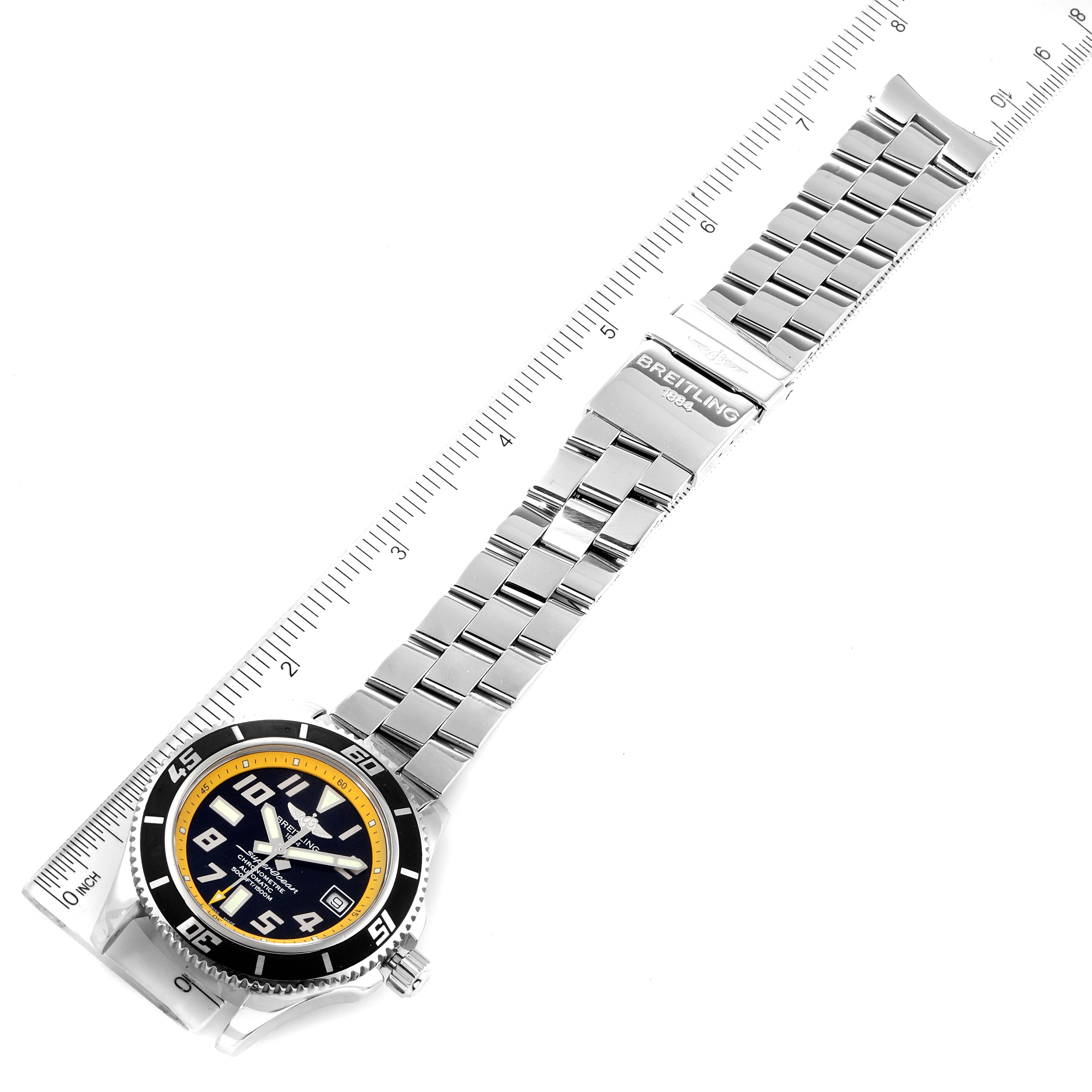 The image shows a top view of the Breitling Superocean A17364 Men's Stainless Steel Black Dial A17364 Men's Stainless Steel Black Dial watch, including its dial, bezel, bracelet, and clasp, with a ruler for scale.