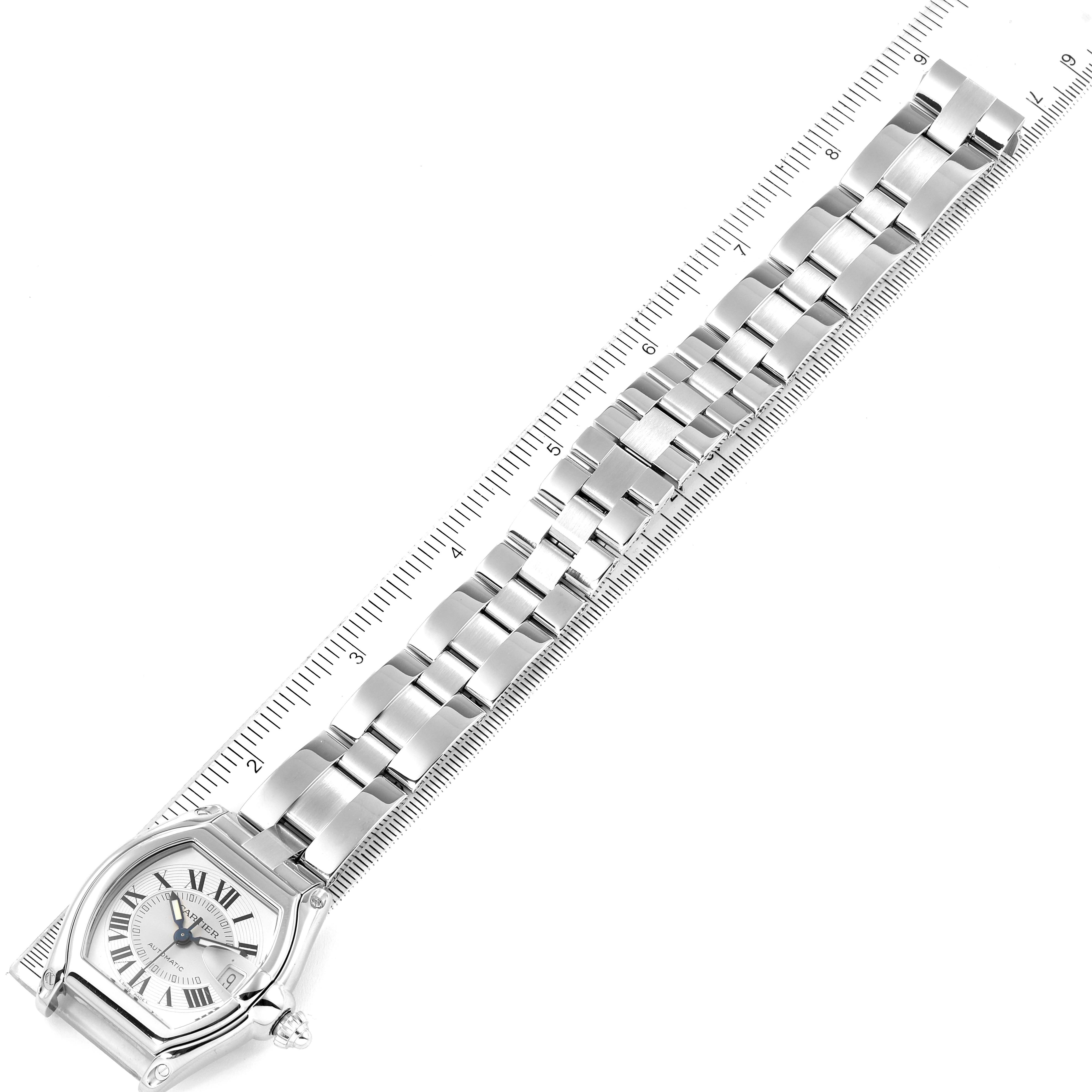 The image shows the Cartier Roadster W62000V3 Men's Stainless Steel Silver Dial W62000V3 Men's Stainless Steel Silver Dial watch from an angled top view, displaying both the face and metal bracelet with an adjacent ruler.