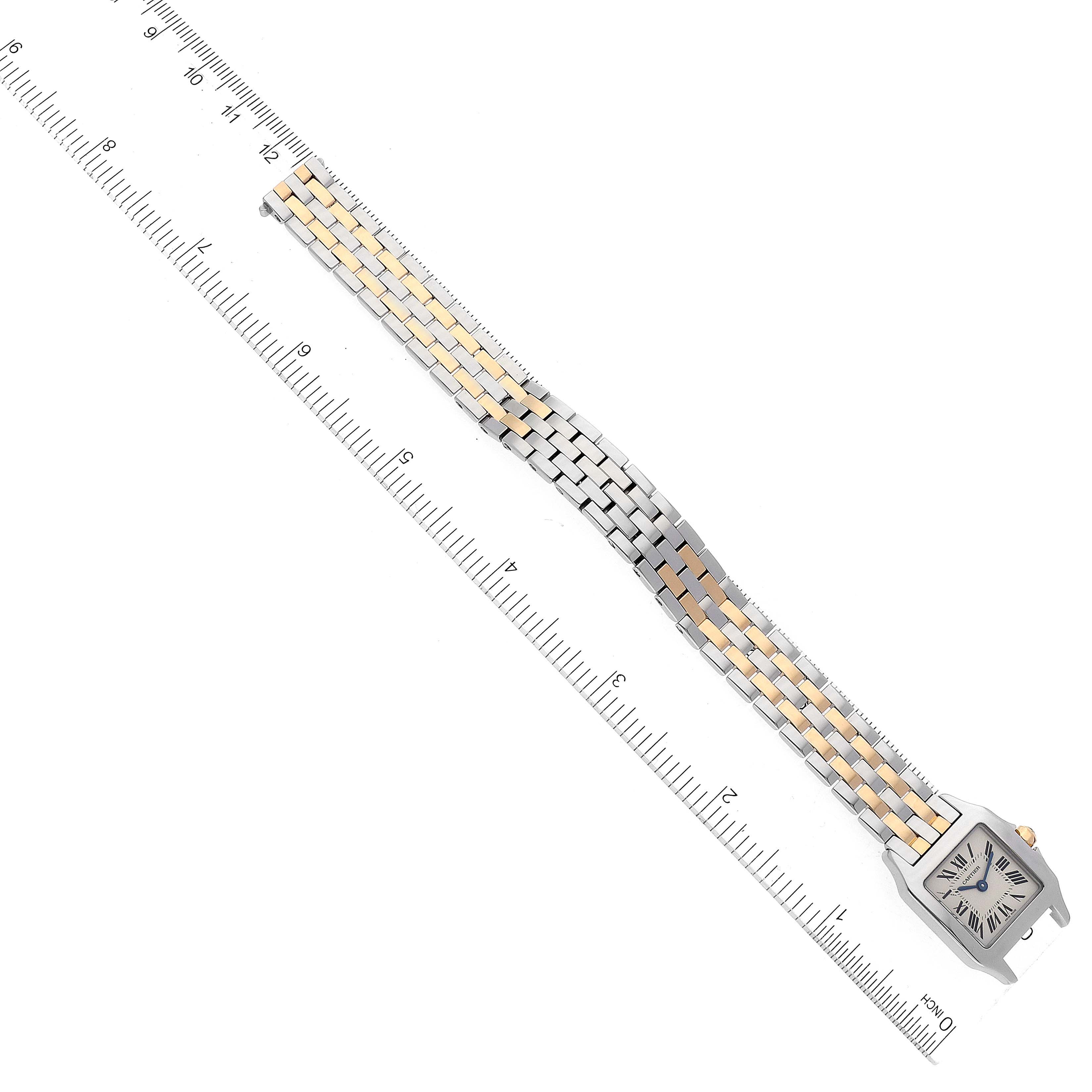 The image shows the entire Santos Demoiselle model by Cartier, including its face and bracelet, next to a ruler for size reference.