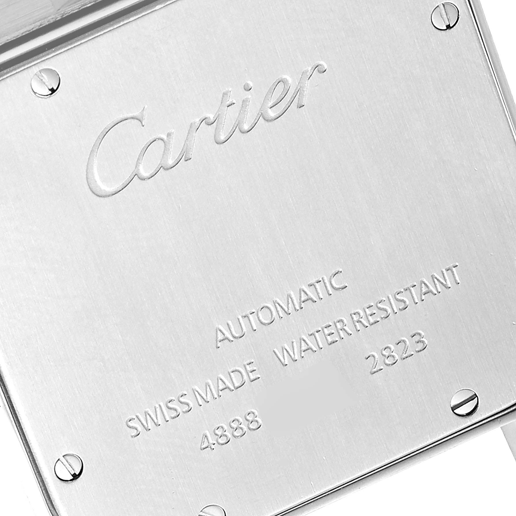 The image shows the back case of a Santos model by Cartier, with engravings and screws visible.