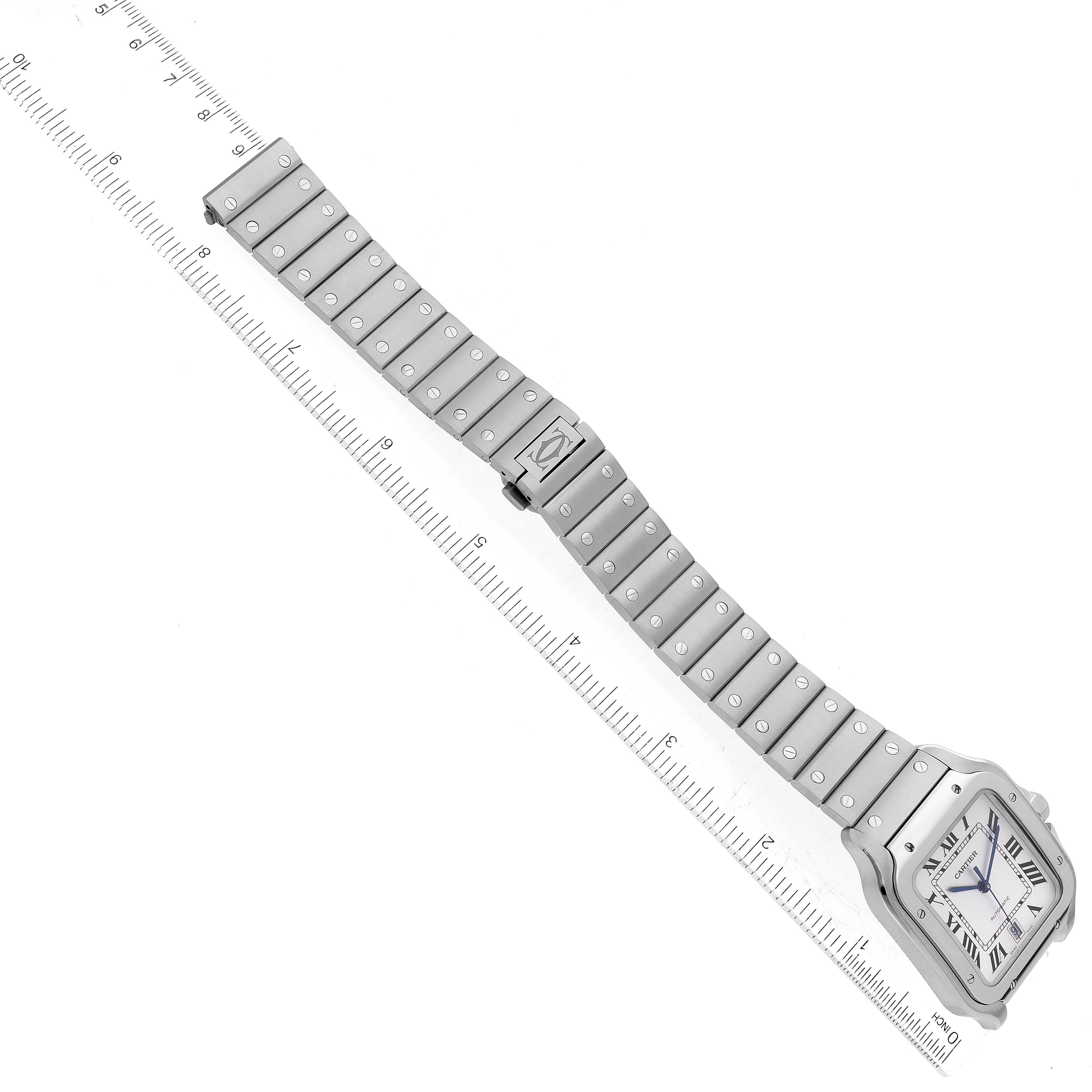 This image shows a Santos Cartier watch lying flat with its case, dial, and full bracelet visible, alongside a ruler for scale.