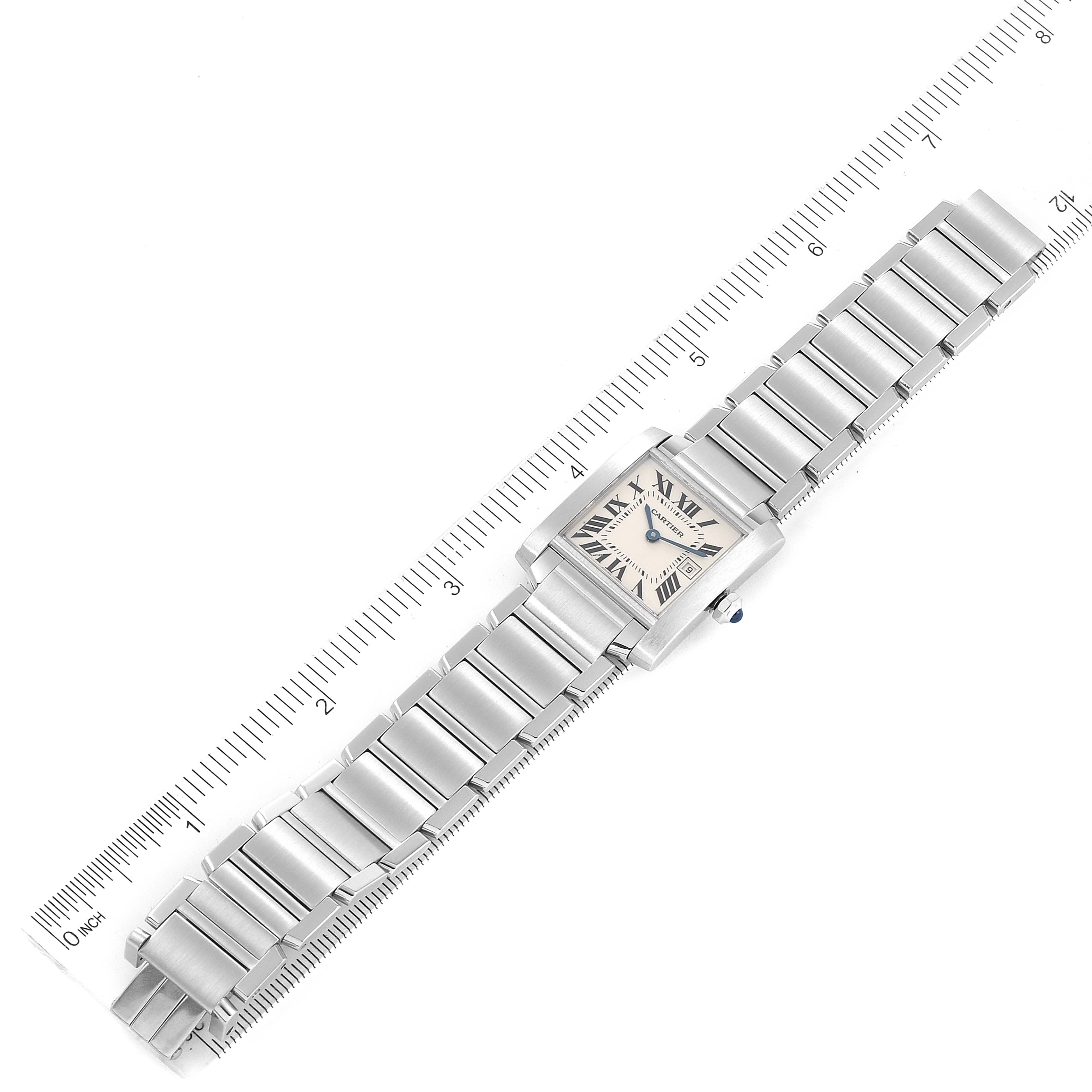 The image shows an overhead view of the Cartier Tank Française watch, with a ruler indicating its length.