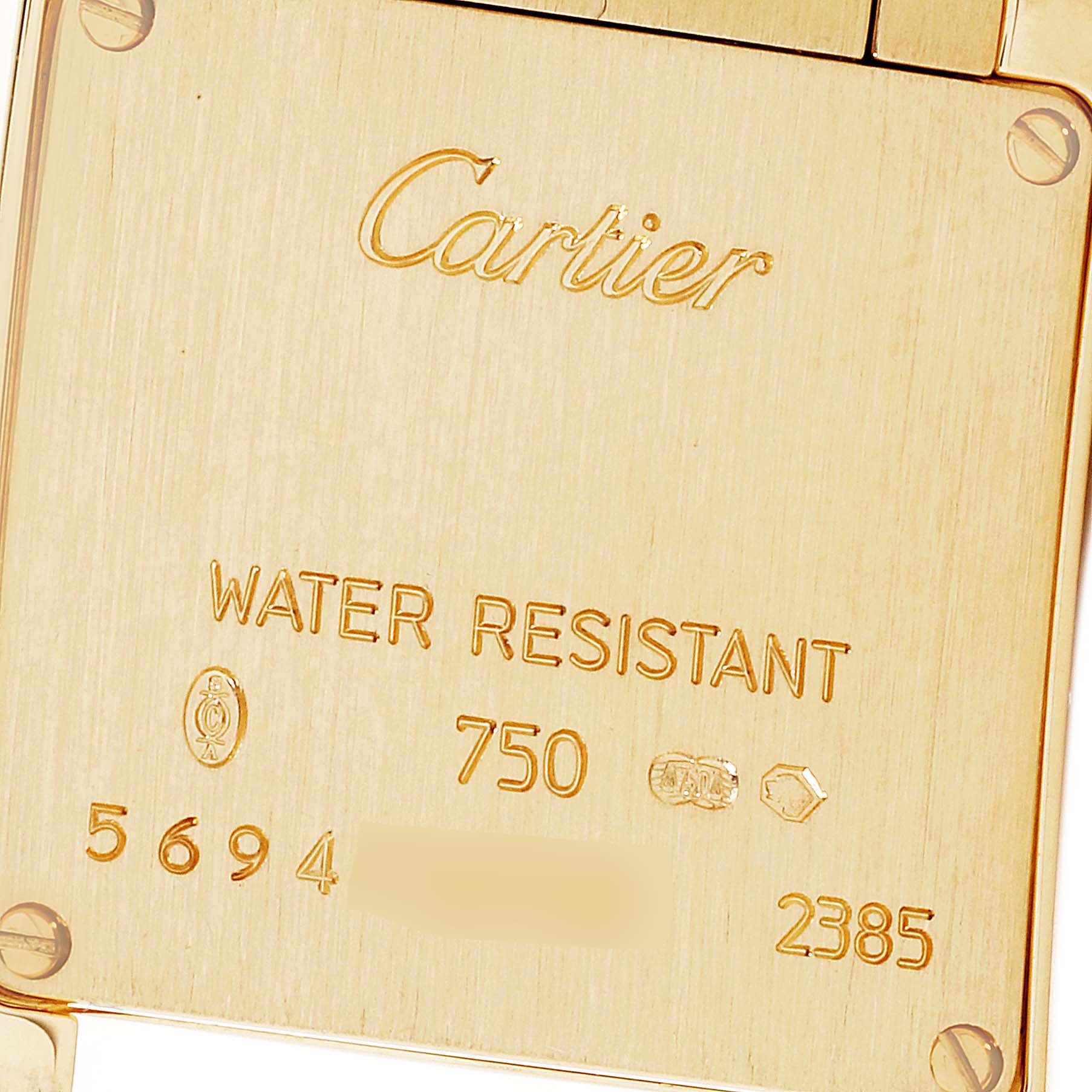 The image shows the back case of a Cartier Tank Francaise W50002N2 Women
s Yellow Gold Silver Dial W50002N2 Women
s Yellow Gold Silver Dial watch with engravings and screws.
