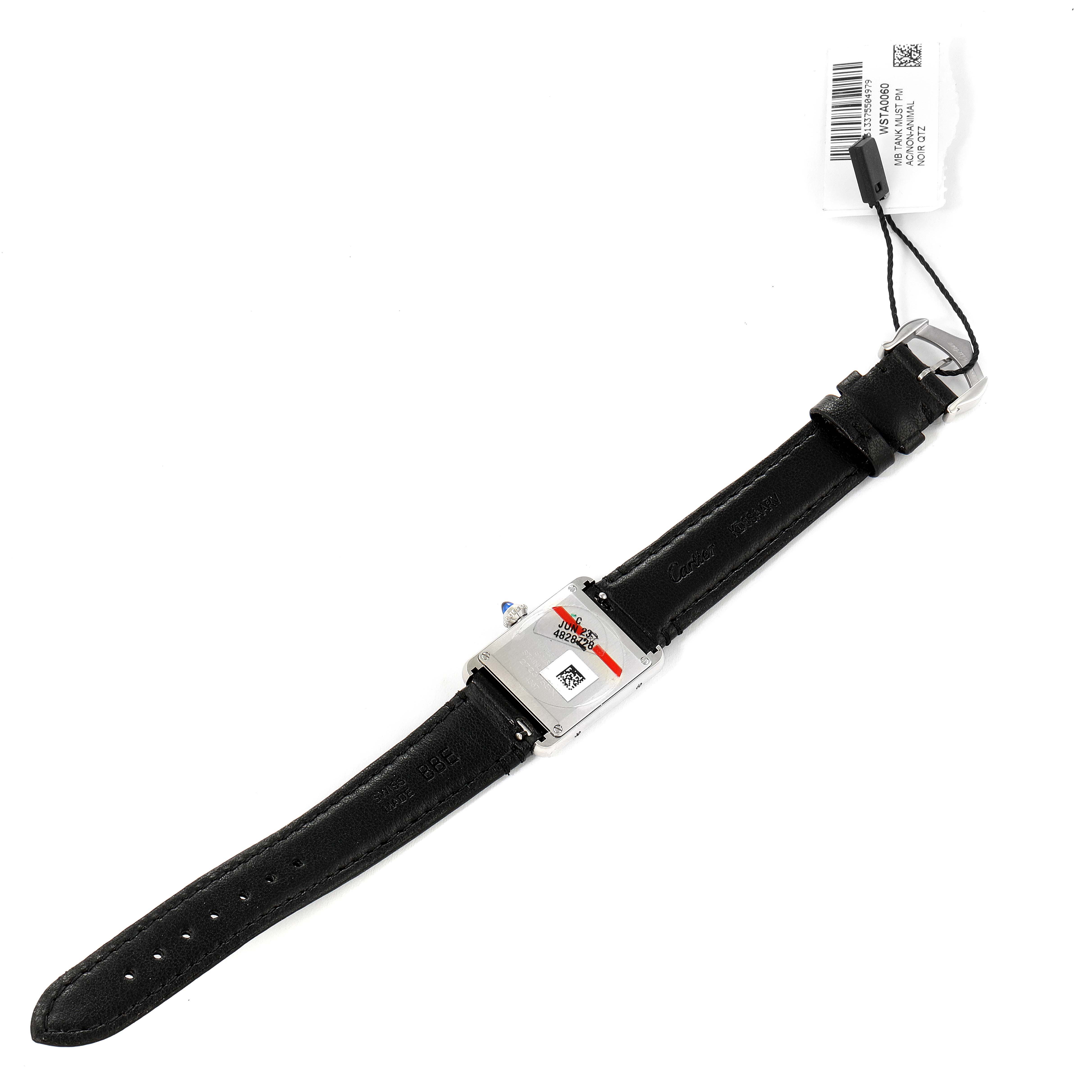 The image shows the back side of a Cartier Tank Must WSTA0060 Women's Stainless Steel Silver Dial WSTA0060 Women's Stainless Steel Silver Dial watch with a black leather strap and a price tag attached.