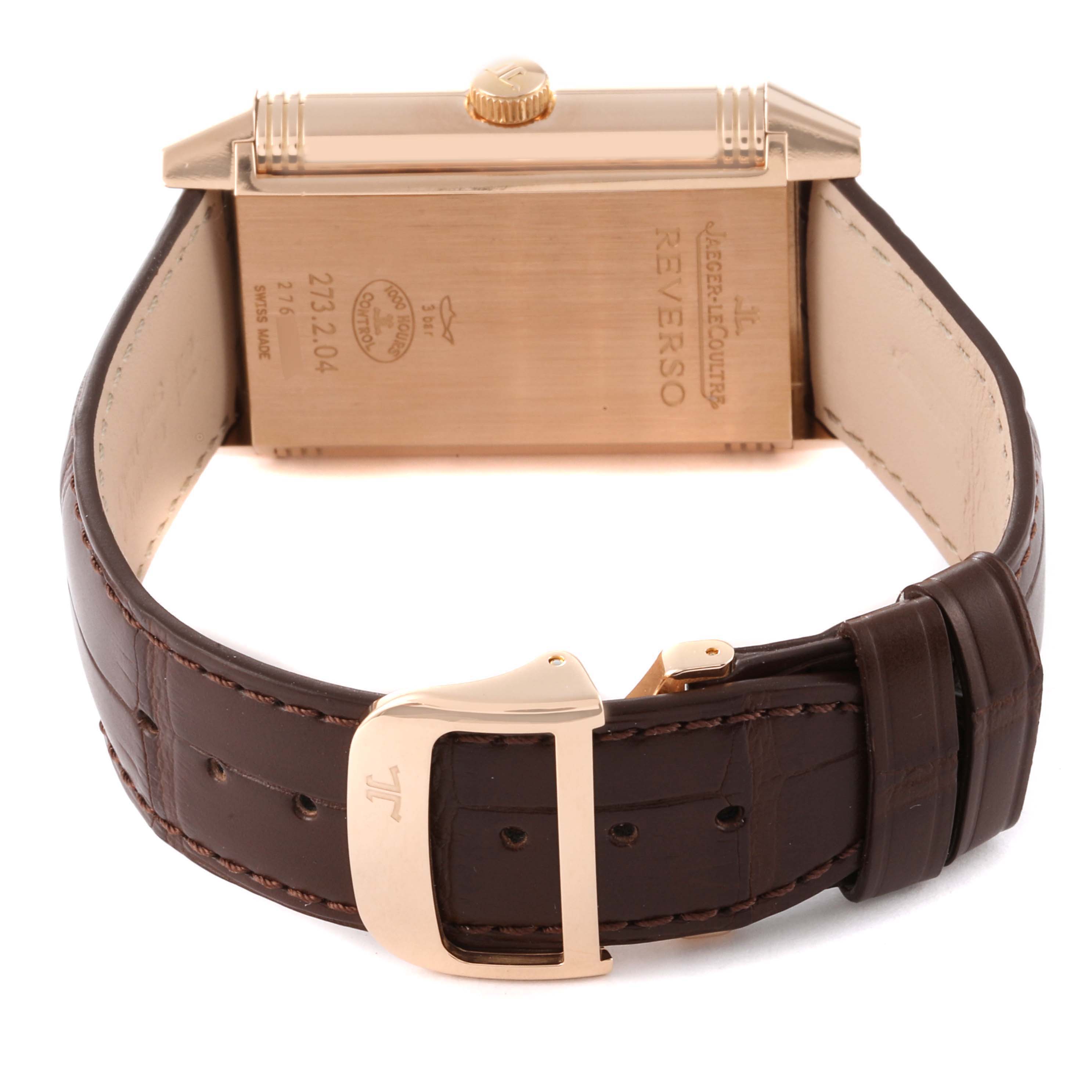 The image shows the back of a Jaeger-LeCoultre Reverso watch and its leather strap, focusing on the buckle and clasp.
