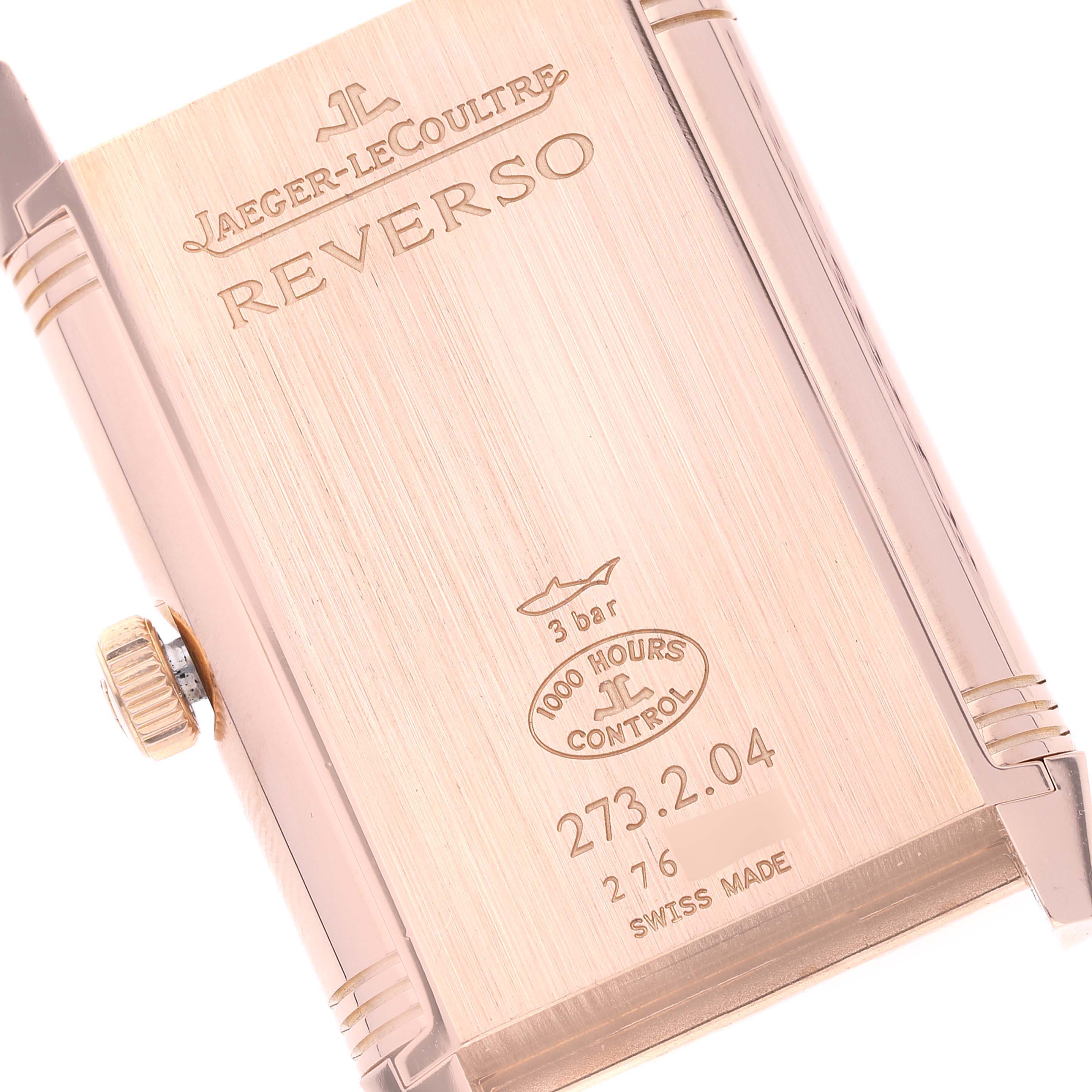 The image shows the case back of a Jaeger-LeCoultre Reverso watch, including the crown and engravings with model details.