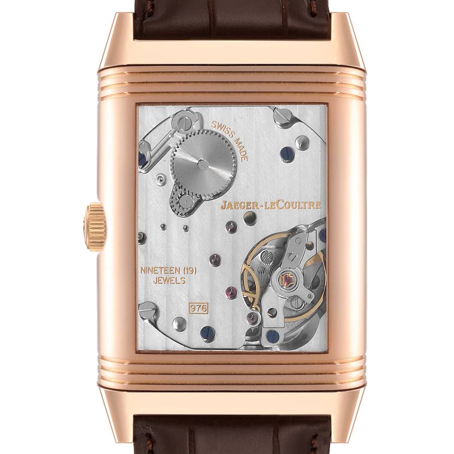 The image shows the back view of a Jaeger-LeCoultre Reverso watch, displaying its intricate mechanical movement.