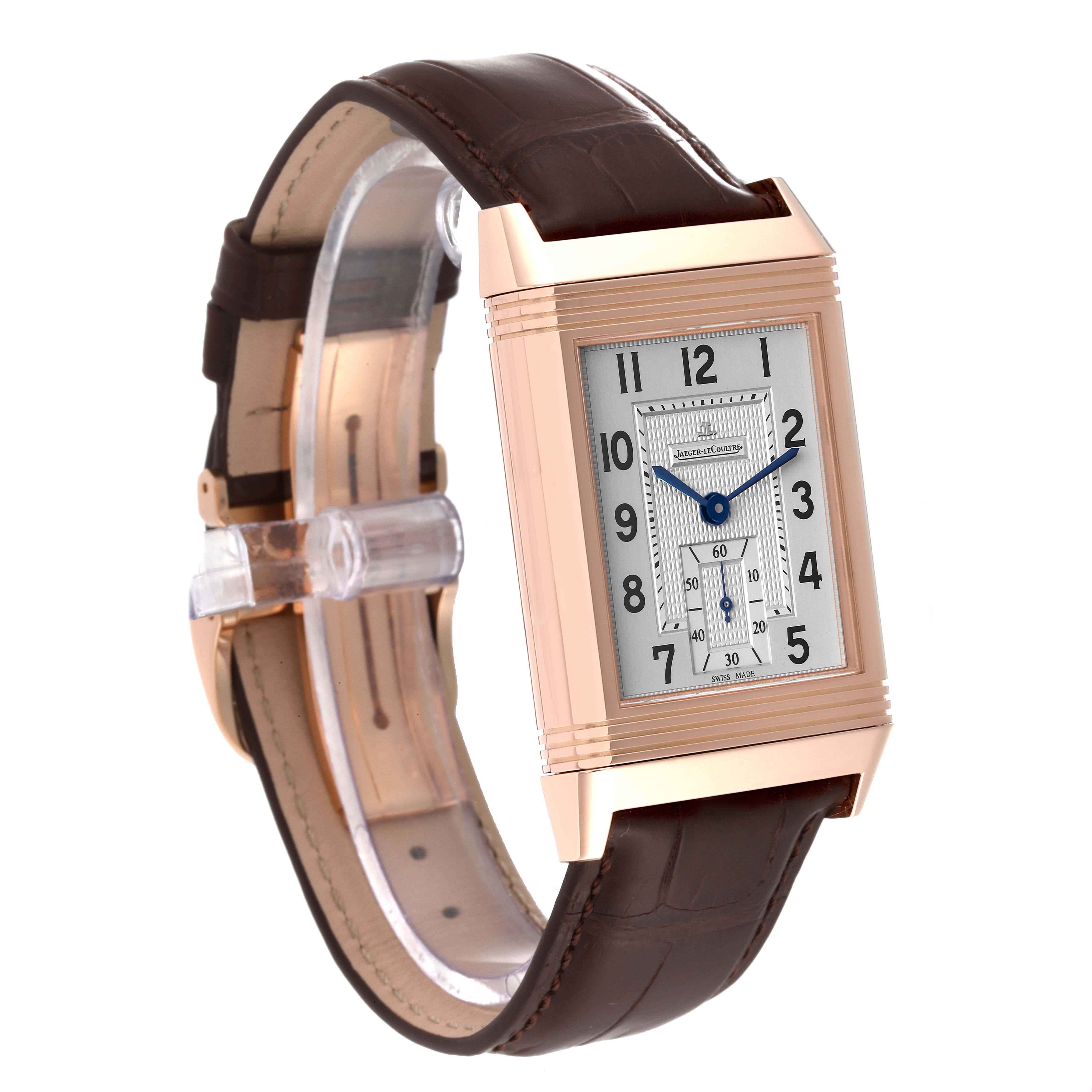 This Reverso model by Jaeger LeCoultre is shown at an angle highlighting its rectangular dial, rose gold case, and leather strap.