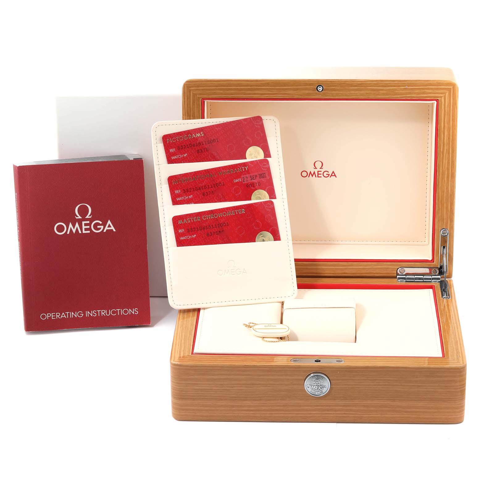 The image displays the Omega Speedmaster 332.10.41.51.11.001 Men's Stainless Steel Red Dial 332.10.41.51.11.001 Men's Stainless Steel Red Dial accessories including cards, an operating manual, and a wooden storage box.