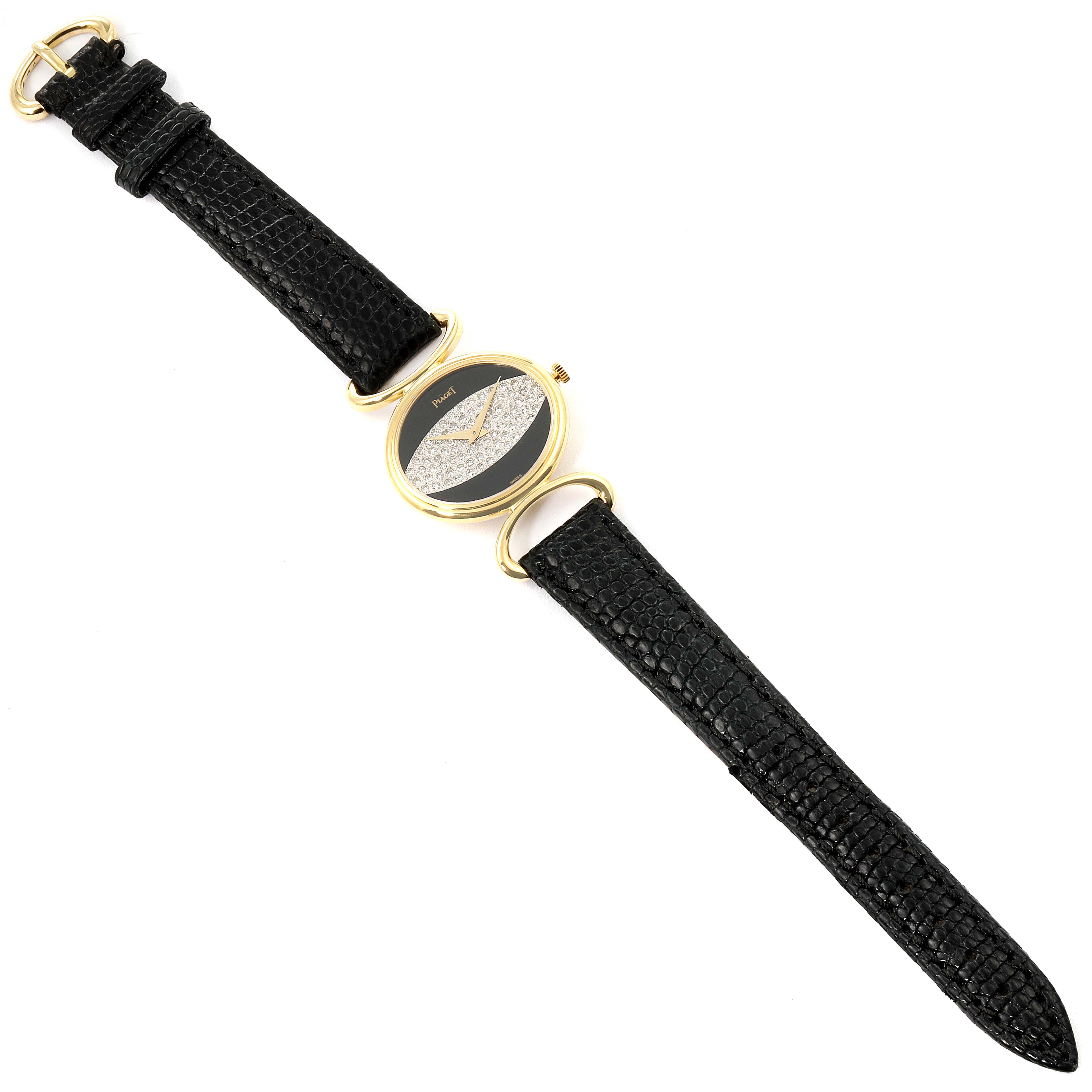 The Piaget 9802 Women's Yellow Gold Black Dial 9802 Women's Yellow Gold Black Dial Classique 9802 Yellow Gold Watch is shown from a top-down angle, displaying the black strap, gold case, and onyx diamond dial.