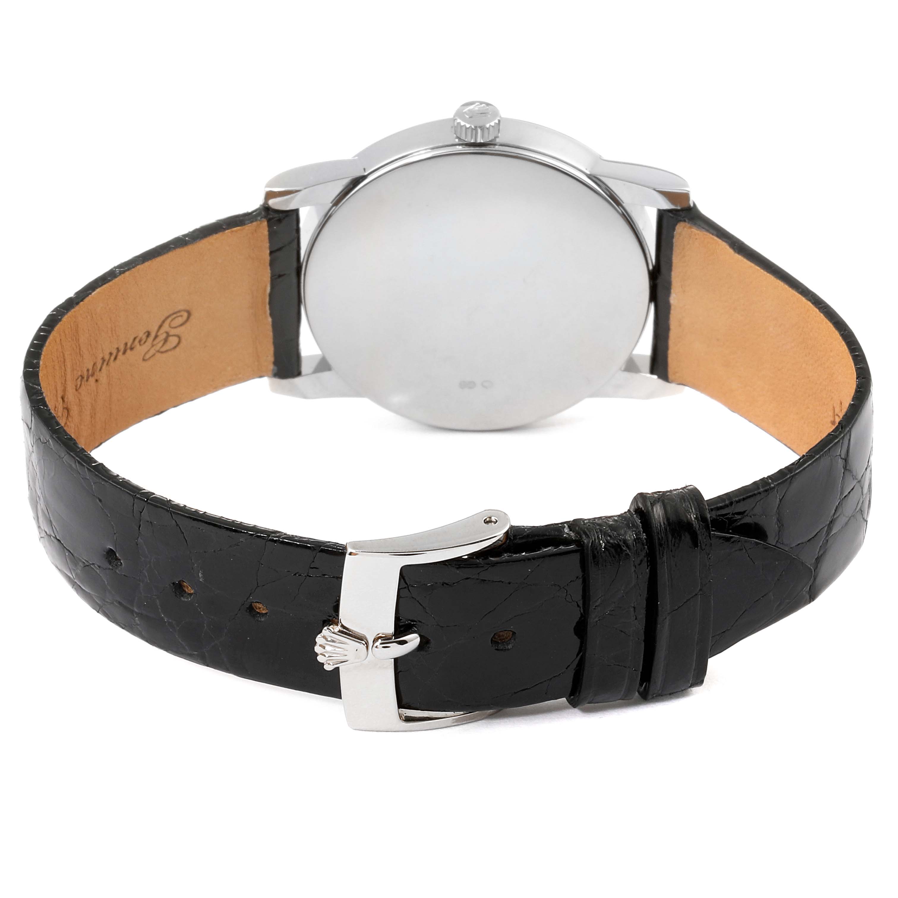 The image shows the back view of a Rolex Cellini 5116 Men's White Gold Black Dial 5116 Men's White Gold Black Dial watch featuring its case back, crown, and leather strap with a clasp.