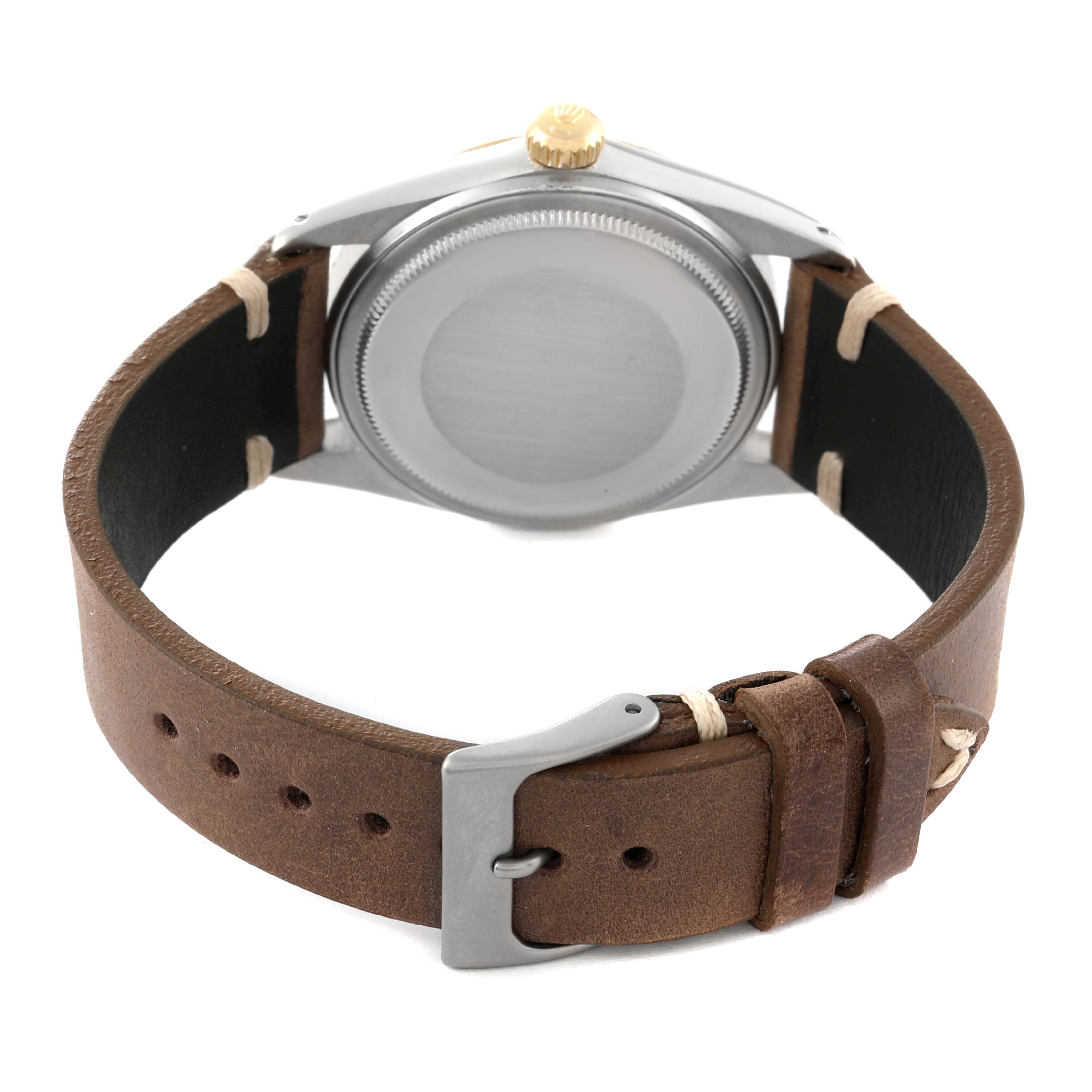 The image shows the back of a Rolex Vintage Collection 16013 Men's Steel and Gold (two tone) Black Dial 16013 Men's Steel and Gold (two tone) Black Dial watch with a brown leather strap and a gold crown.