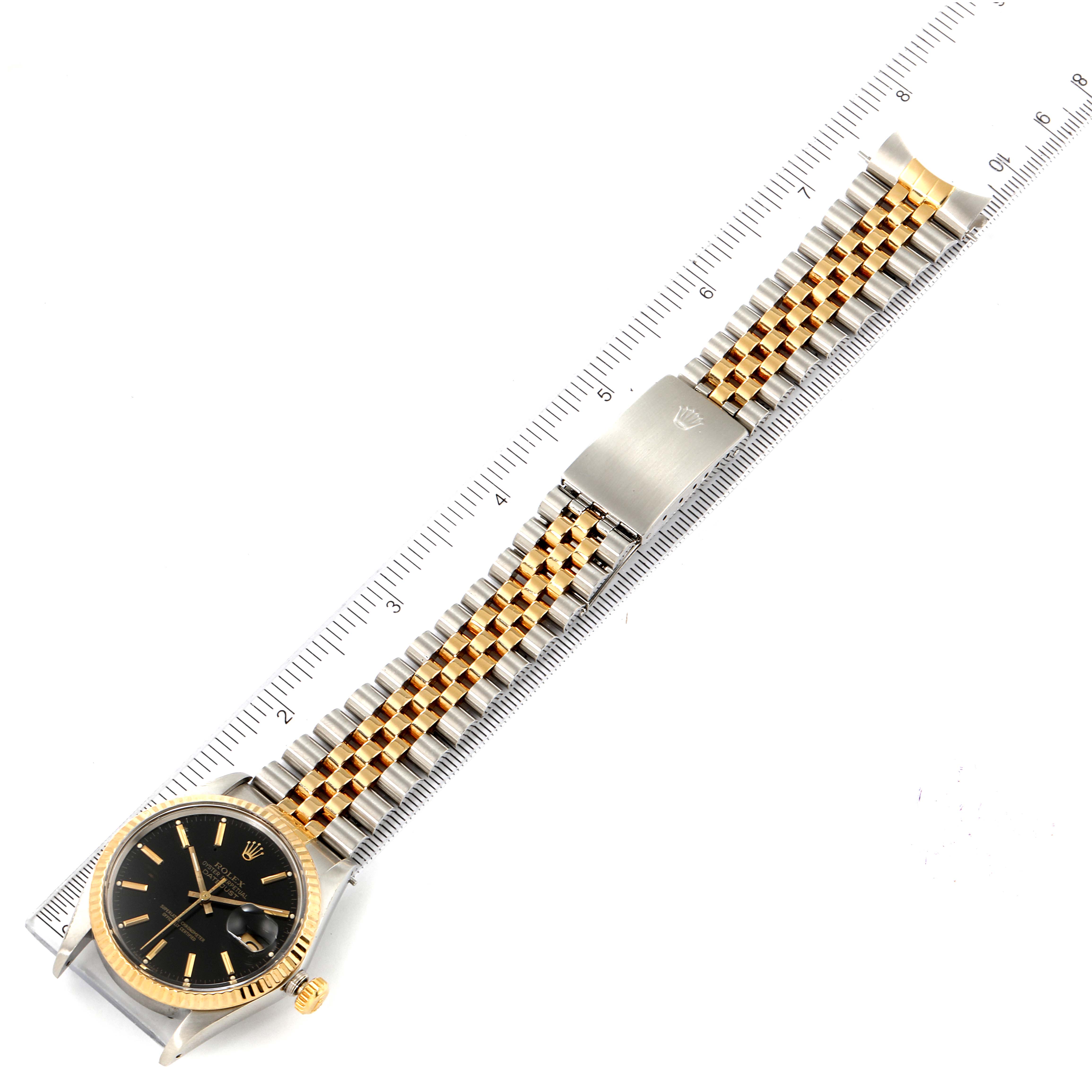 The Rolex Vintage Collection 16013 Men's Steel and Gold (two tone) Black Dial 16013 Men's Steel and Gold (two tone) Black Dial watch is displayed from above, showing the entire face, band, and clasp next to a measuring ruler.