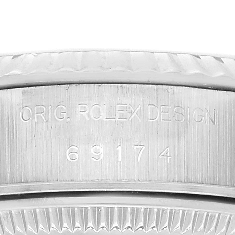 This image shows an engraving on the stainless steel case of a Rolex Datejust 69174 Women's Stainless Steel White Dial 69174 Women's Stainless Steel White Dial model, with part of the bezel visible.