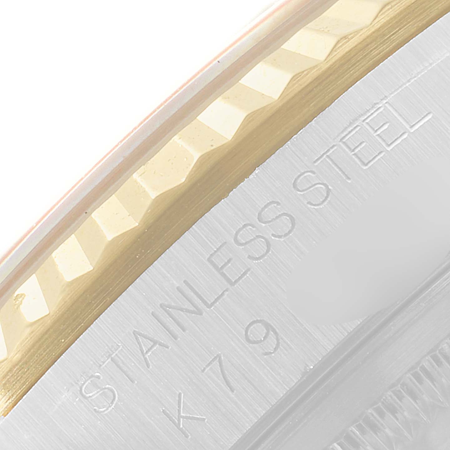 The image shows a close-up of the Rolex Datejust 16233 Men's Steel and Gold (two tone) Champagne Dial 16233 Men's Steel and Gold (two tone) Champagne Dial model's fluted bezel and part of the case with engraved "STAINLESS STEEL."