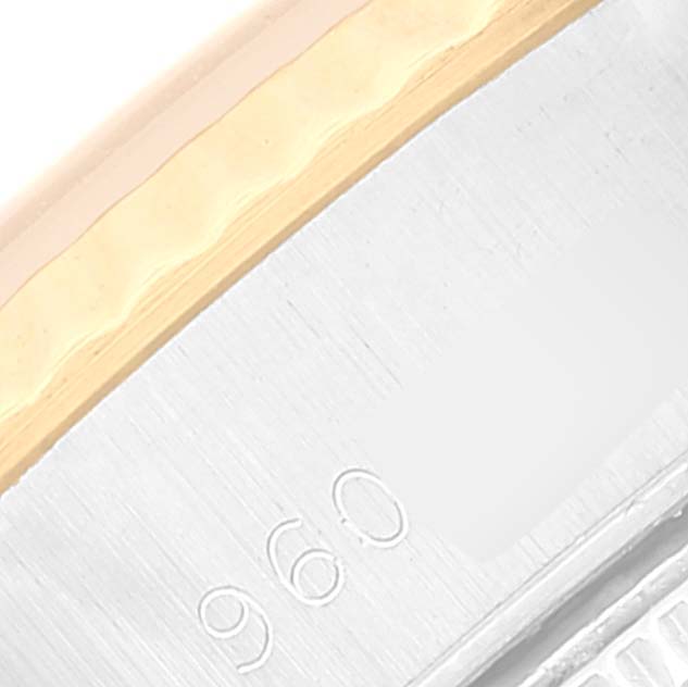This close-up image shows the side of the case of a Rolex Datejust 69173 Women's Steel and Gold (two tone) White Dial 69173 Women's Steel and Gold (two tone) White Dial watch, highlighting the edge and part of an engraving.
